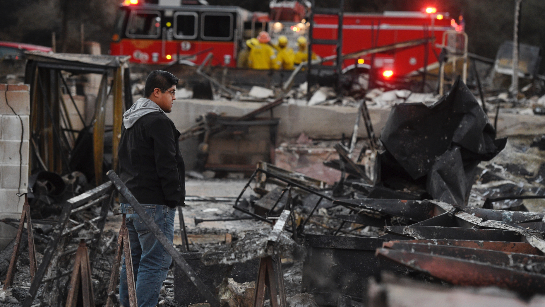 Ricky Alvarado looks over the charred remains of his home at the Seminole Springs Mobile Home Park, Sunday, Nov. 11, 2018, after the neighborhood was devastated by wildfires in Agoura Hills, Calif. (AP Photo/Chris Pizzello)