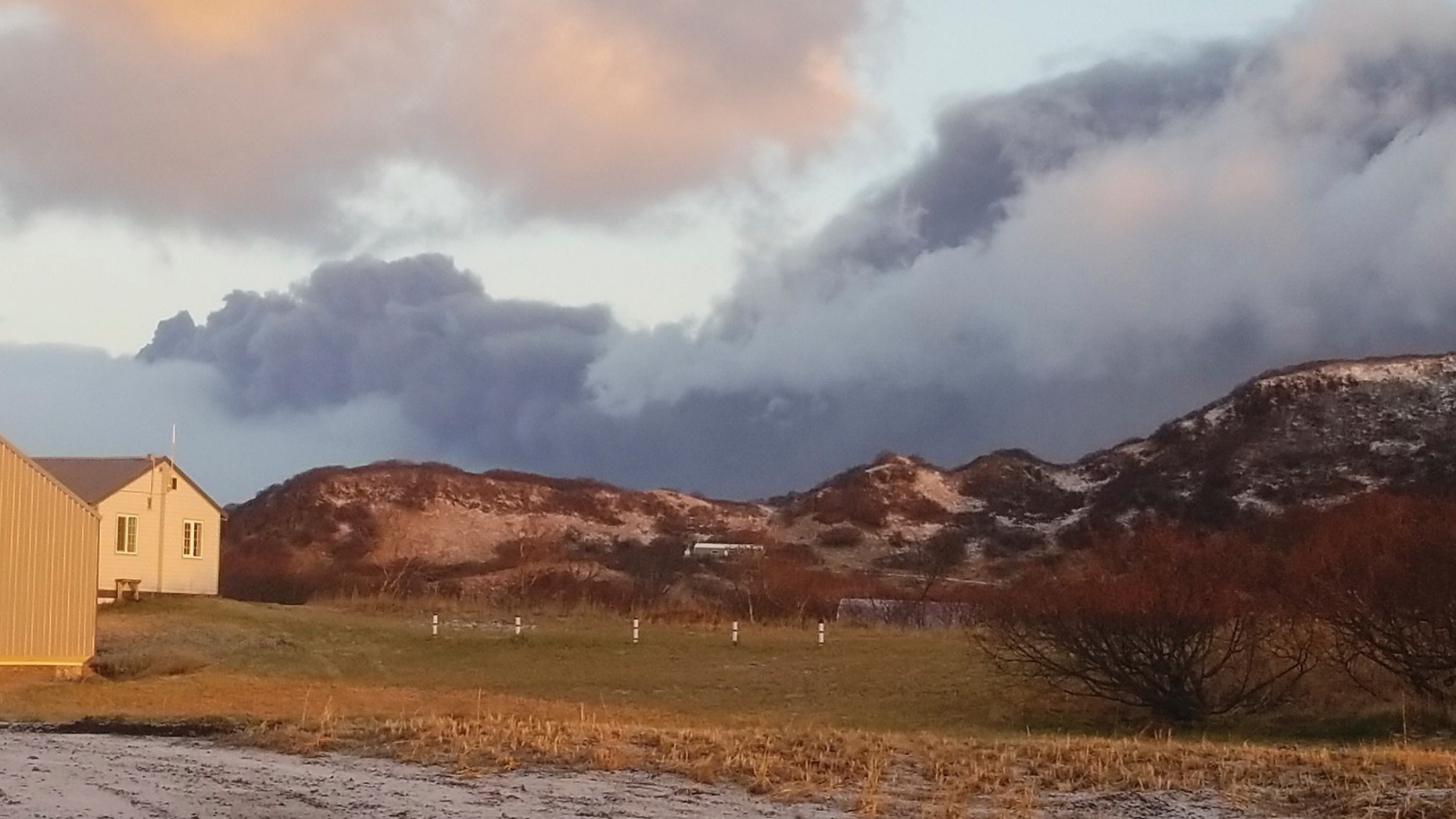 A black ash cloud from Alaska's Mount Veniaminof passes the community of Perryville, Alaska, on Wednesday, Nov. 21, 2018. Alaska Volcano Observatory scientists said the overnight ash emissions from Mount Veniaminof generated an ash plume that drifted more than 150 miles (241 kilometers) to the southeast. (Victoria Tague via AP)