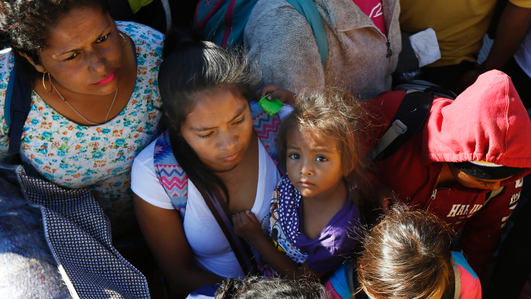 Migrants traveling with a caravan hoping to reach the U.S. border, wait to board a bus in La Concha, Mexico, Wednesday, Nov. 14, 2018. Buses and trucks are carrying some migrants into the state of Sinaloa along the Gulf of California and further northward into the border state of Sonora. The bulk of the main caravan appeared to be about 1,100 miles from the border, but was moving hundreds of miles per day. (AP Photo/Marco Ugarte)