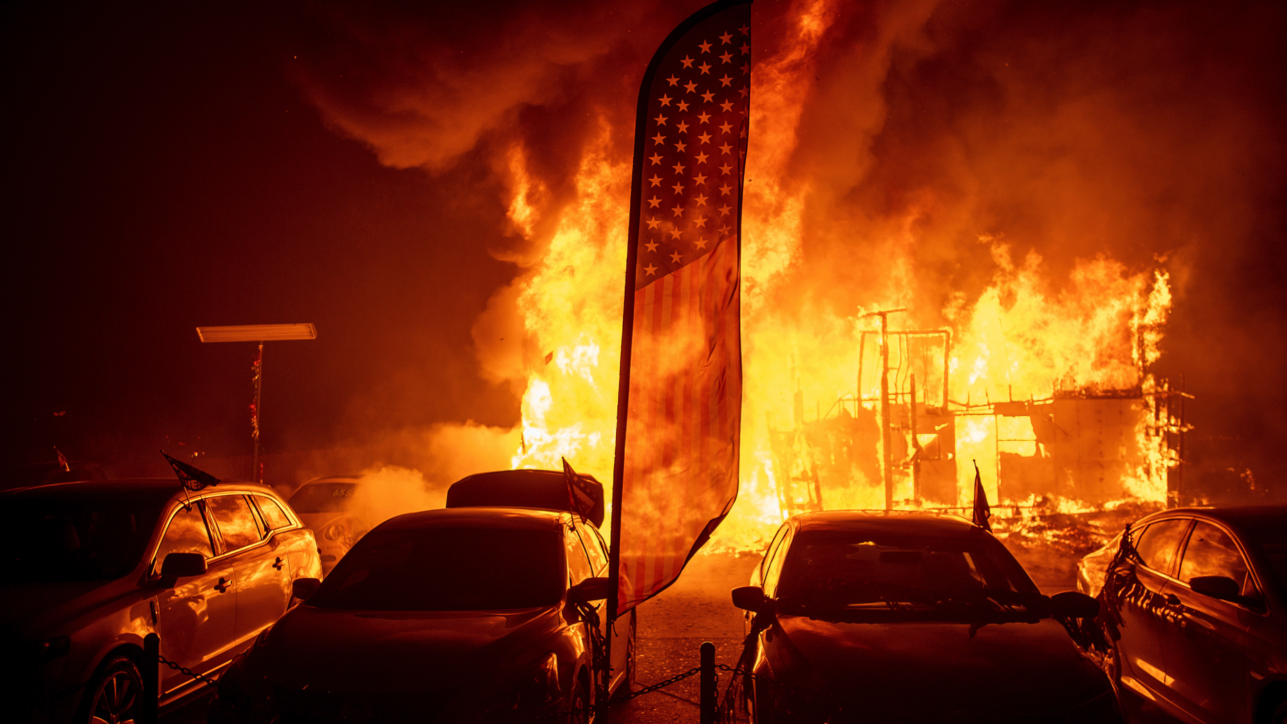 Flames consume a car dealership as the Camp Fire tears through Paradise, Calif., on Thursday, Nov. 8, 2018. Tens of thousands of people fled a fast-moving wildfire Thursday in Northern California, some clutching babies and pets as they abandoned vehicles and struck out on foot ahead of the flames that forced the evacuation of an entire town and destroyed hundreds of structures. (AP Photo/Noah Berger)
