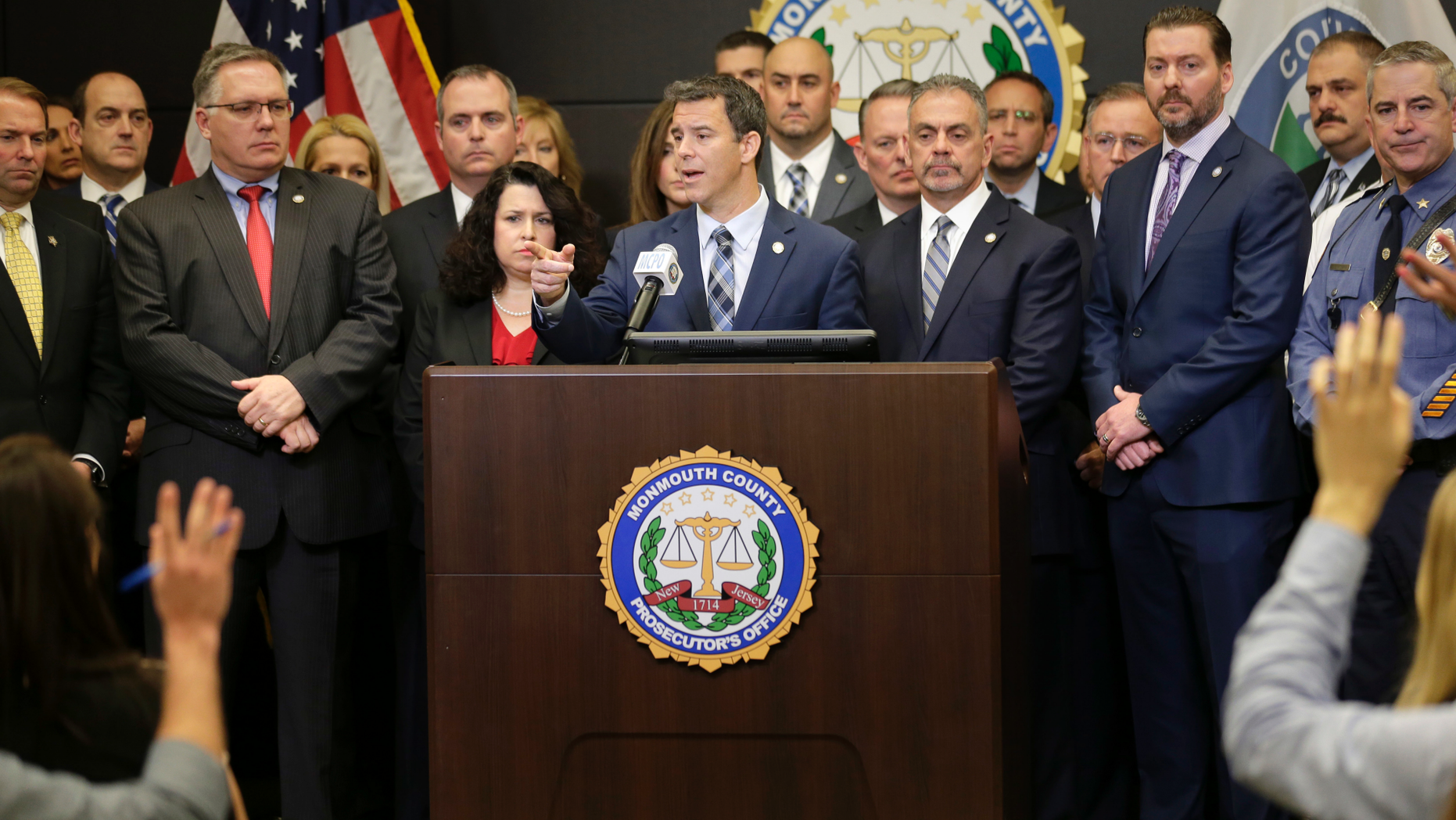 Monmouth County Prosecutor Christopher Gramiccioni, center, speaks during a news conference in Freehold, N.J., Thursday, Nov. 29, 2018. Prosecutors say financial motives led a New Jersey technology executive to kill his brother, the brother's wife and their young children before setting fire to their two homes. Paul Caneiro is now charged with murder in the deaths of 50-year-old Keith Caneiro, his 45-year-old wife Jennifer and their children, 11-year-old Jesse and 8-year-old Sophia. (AP Photo/Seth Wenig)