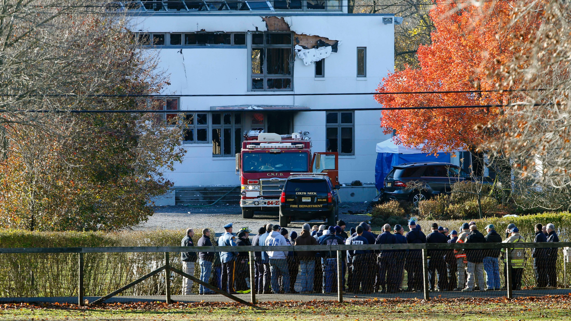 FILE - In this Nov. 21, 2018 file photo, authorities gather in Colts Neck, N.J., to investigate the aftermath of fatal fire that killed two children and two adults. The bodies of Keith Caneiro, his wife Jennifer Caneiro, their children Jesse, 11, and Sophia 8, were found at the scene: all victims of an apparent homicide. (AP Photo/Noah K. Murray, File)
