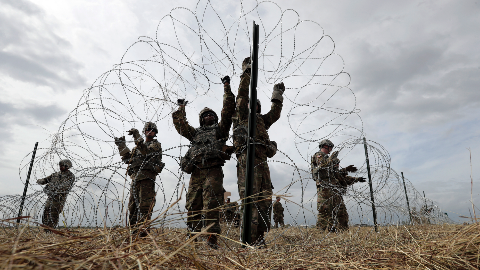 FILE - In this Sunday, Nov. 4, 2018 file photo, members of a U.S Army engineering brigade place concertina wire around an encampment for troops, Department of Defense and U.S. Customs and Border Protection personnel near the U.S.-Mexico International bridge in Donna, Texas. (AP Photo/Eric Gay)