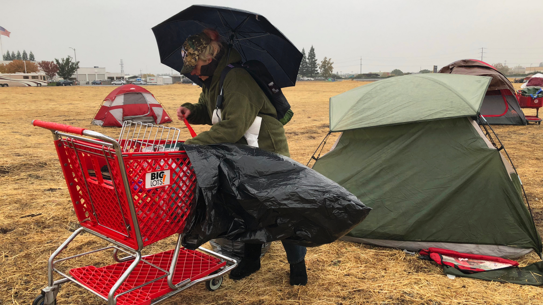 Amy Sheppard packs up items outside her tent in a Walmart parking lot in Chico, Calif., that's been a makeshift campground for people displaced by wildfire, Wednesday morning, Nov. 21, 2018. Sheppard lost her home in Magalia to the Camp fire. She was staying in the tent for four days with her sister and 1-year-old niece. They are moving to a motel because of rain that began Wednesday. (AP Photo/Kathleen Ronayne)