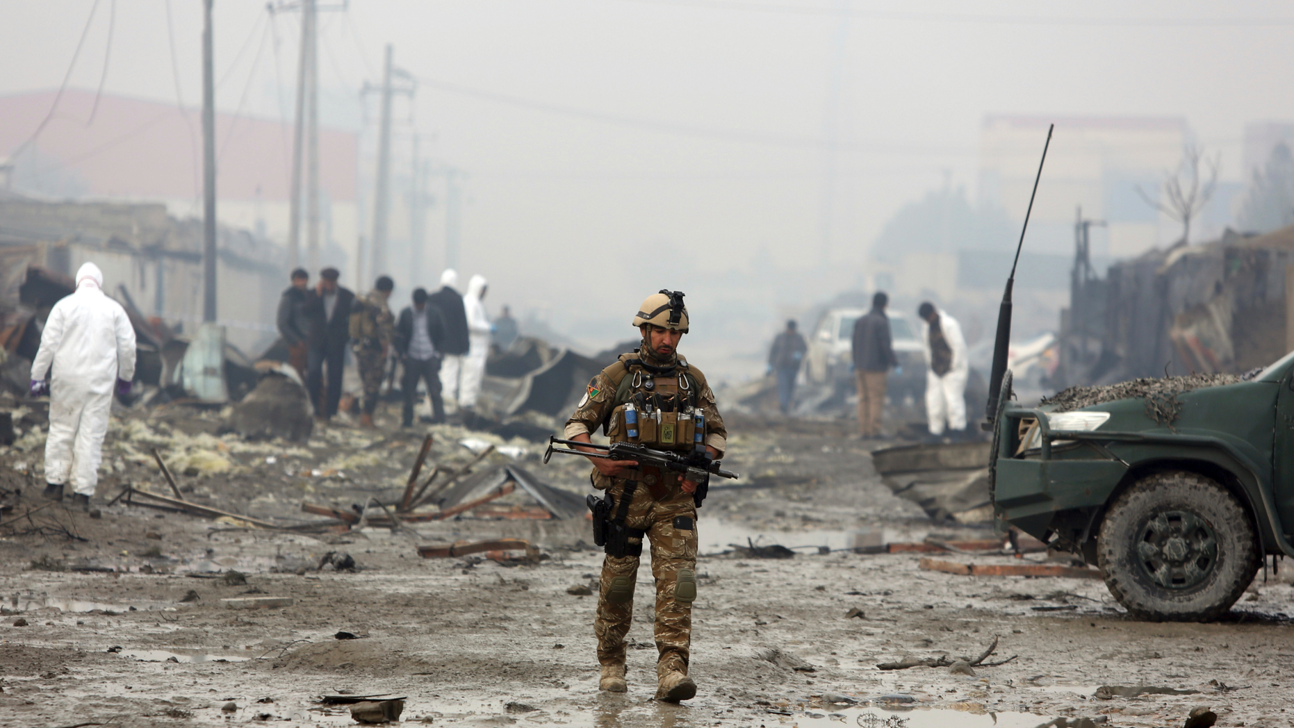 An Afghan security force walks around the site of suicide bomb attack in Kabul, Afghanistan, Thursday, Nov. 29, 2018. Taliban insurgents staged a coordinated attack targeting a security firm in the Afghan capital on Wednesday, killing people and wounding others.