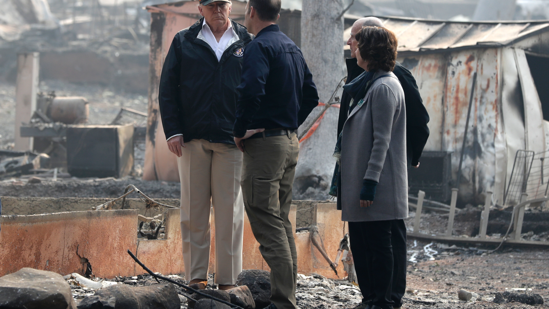 President Donald Trump talks to FEMA Administrator Brock Long as he tours Paradise, Calif., California Gov. Jerry Brown and Paradise Mayor Jody Jones during a visit to a neighborhood impacted by the wildfires, Saturday, Nov. 17, 2018. (AP Photo/Evan Vucci)
