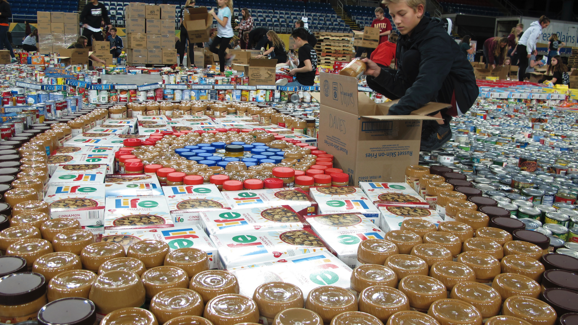 Cole Brekke, an eighth-grade student at Discovery Middle School in Fargo, N.D., packs up canned goods for the annual "Fill The Dome" food drive at the Fargodome indoor stadium on Tuesday, Nov. 20, 2018. This is the 12th year of the event and includes participation by high school, junior high and elementary schools from about 50 schools in the area. Officials say their efforts will provide about 300,000 meals for families in the region. (AP Photo/Dave Kolpack)