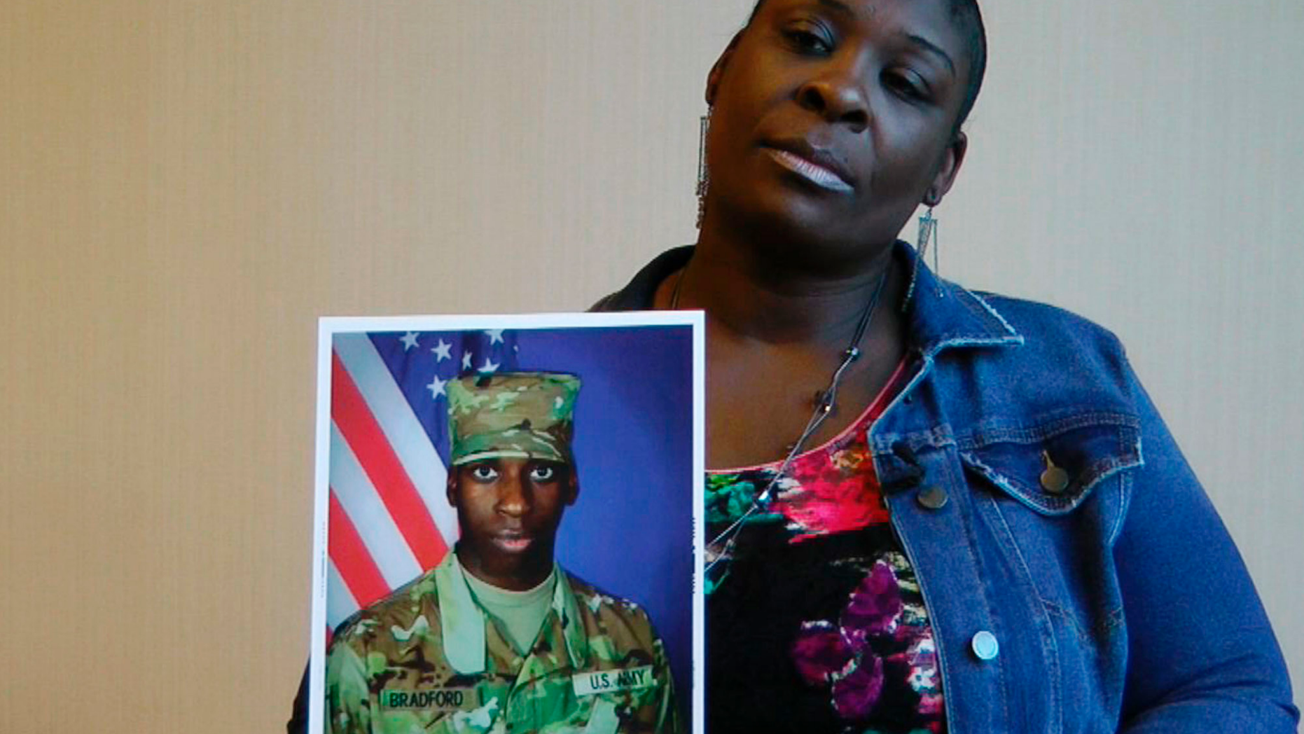 In this still image taken from the video, April Pipkins holds a photograph of her deceased son, Emantic.