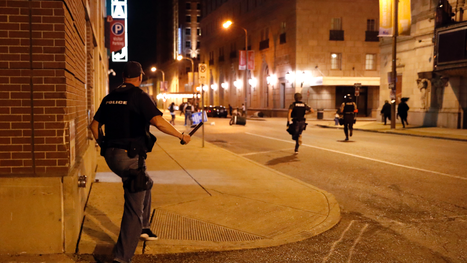 FILE - In this Sept. 17, 2017 file photo, police chase vandals as demonstrators march in response to a not guilty verdict in the trial of former St. Louis police officer Jason Stockley in St. Louis. Stockley was acquitted in the 2011 killing of a black man following a high-speed chase. Four St. Louis police officers were indicted Thursday, Nov. 29, 2018, by a federal grand jury. Three are accused of beating an undercover colleague during a protest over the acquittal of Stockley, a white officer who was accused in the death of a black suspect. Those three and a fourth officer are also accused of conspiring to cover up the crime. (AP Photo/Jeff Roberson, File)