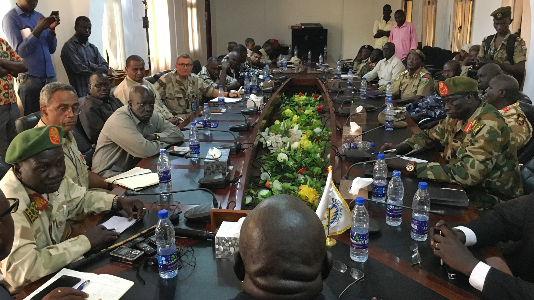In this photo taken Thursday, Nov. 22, 2018, a South Sudan armed opposition commander Ashab Khamis, far-left, and a government army Gen. Keer Kiir Keer, far-right, attend high level talks where both sides exchanged accusations of violating the peace agreement, in Wau, South Sudan. The Associated Press witnessed the first meeting between the Wau region leaders of South Sudan's army and armed opposition since a groundbreaking peace deal, and the country's peace rests on whether the opposing sides can put a vicious past behind. (AP Photo/Sam Mednick)