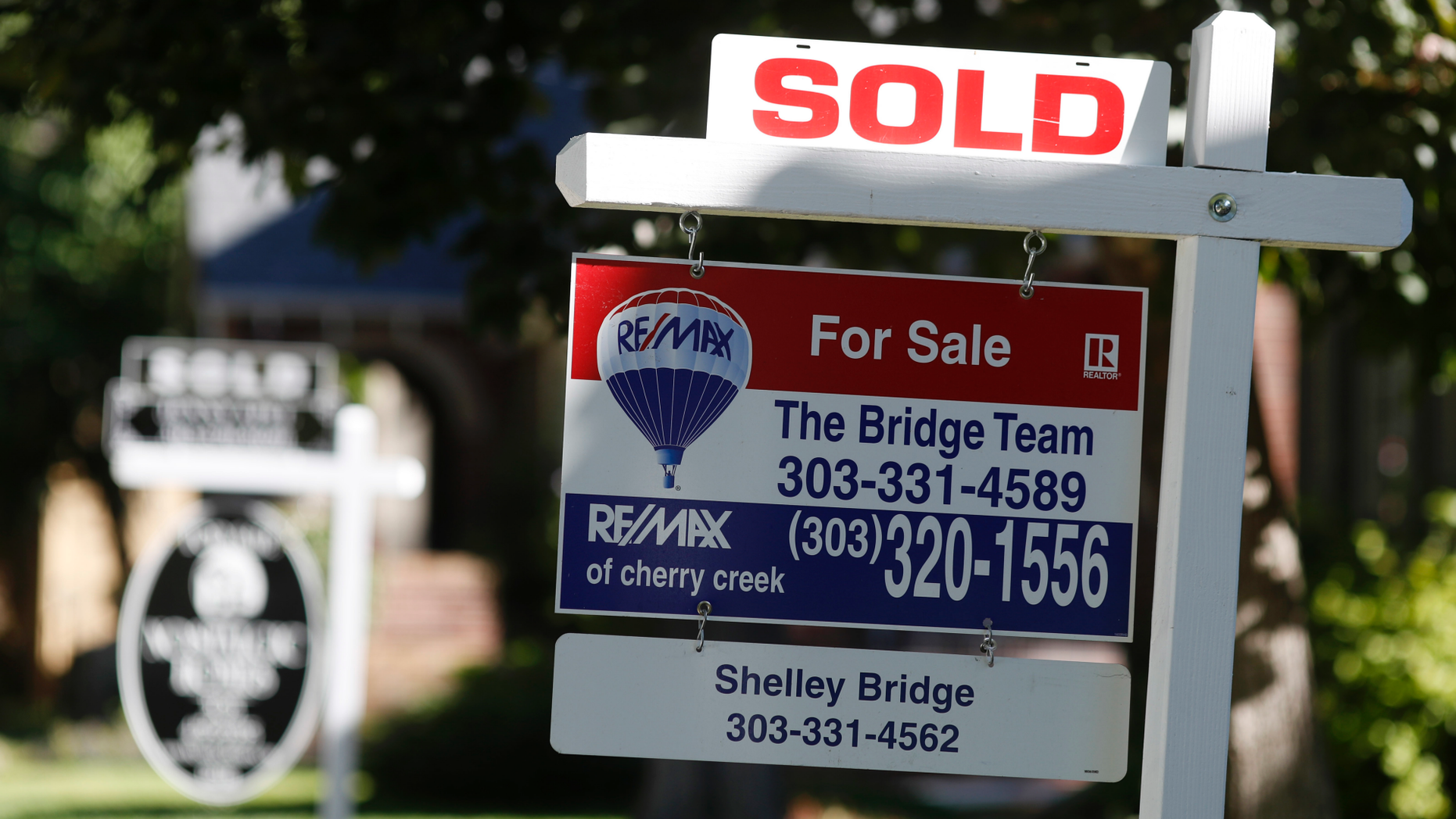 FILE- In this Aug. 30, 2018, file photo sold placards top sale signs outside homes on the market in Denver. On Wednesday, Nov. 21, the National Association of Realtors reports on sales of existing homes in October. (AP Photo/David Zalubowski, File)