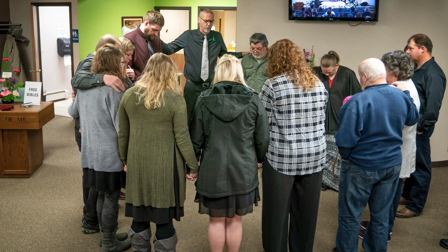 Rev. Jim Woldhuis prays with family members before entering the sanctuary for the funeral for 32-year-old Sara Schneider and her 10-year-old daughter, Haylee Hickle. The community of Chippewa Falls gathers as one Thursday, Nov. 8,2018, to mourn and remember three Girl Scouts and a mother who were run over and killed last weekend while picking up litter on a two-lane highway outside of town. Funerals for Sara Jo Schneider and her daughter Haylee Hickle were held on Thursday. (Glen Stubbe/Star Tribune via AP)
