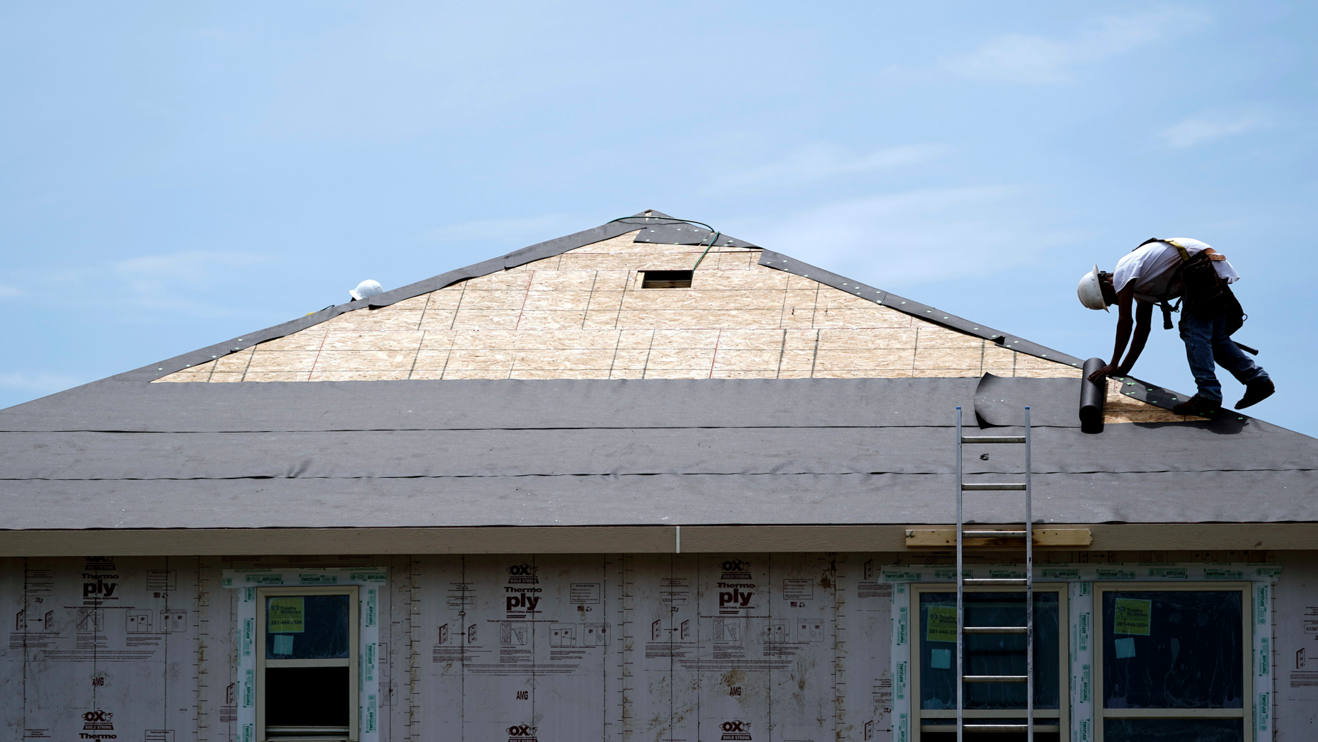 FILE- In this July 23, 2018, file photo a construction worker puts down roofing paper on a new home as he works outside in Houston. On Tuesday, Nov. 20, the Commerce Department reports on U.S. home construction in October. (AP Photo/David J. Phillip, File)