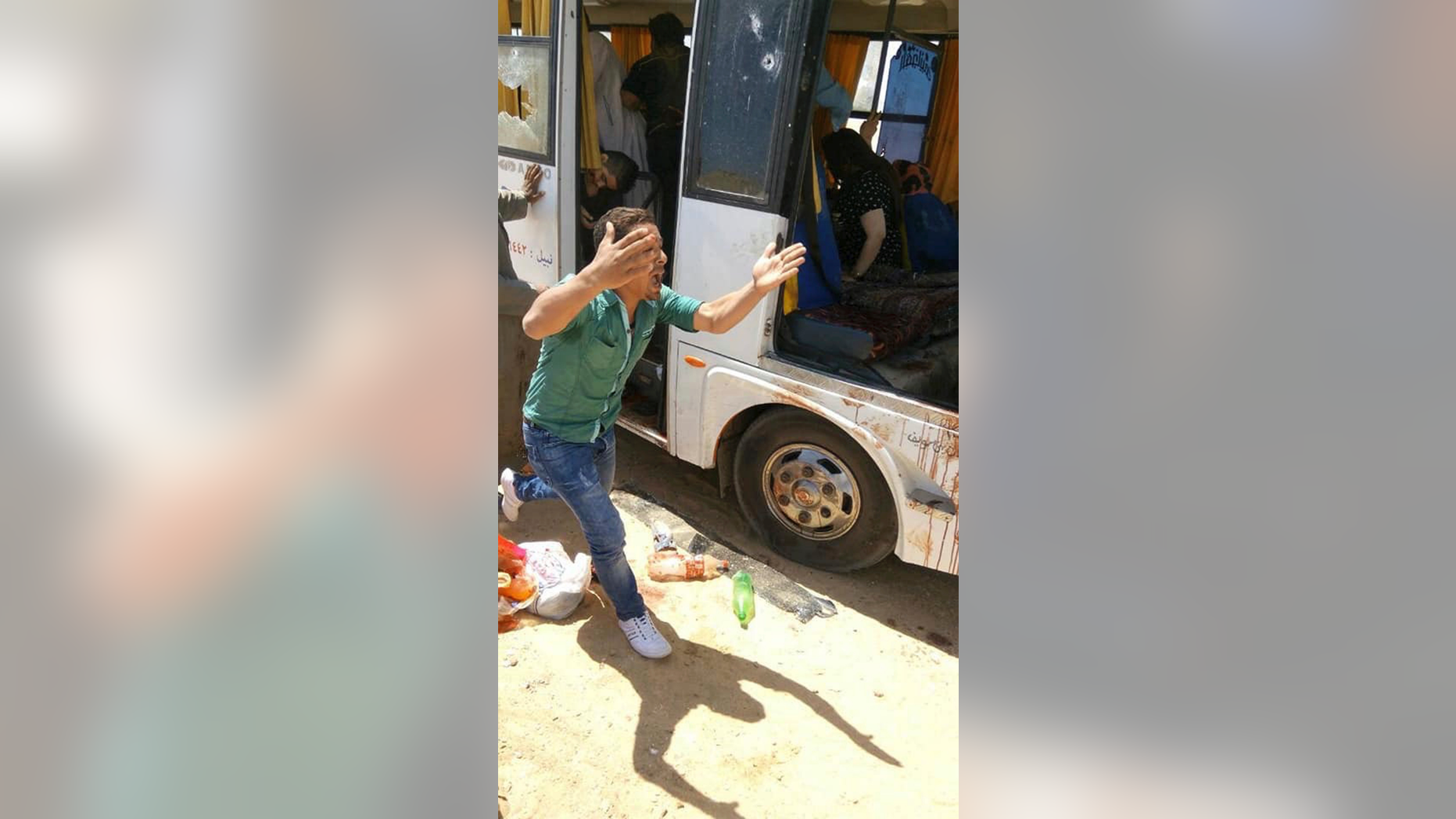 A man screams beside a bus carrying Coptic Christians which came under attack outside Cairo, Friday, Nov. 2, 2018. Islamic militants on Friday ambushed a bus carrying Christian pilgrims on their way to a remote desert monastery south of the Egyptian capital, killing at least seven and wounding a dozen more, the Interior Ministry said.(Egypt’s Coptic Orthodox Church via AP)