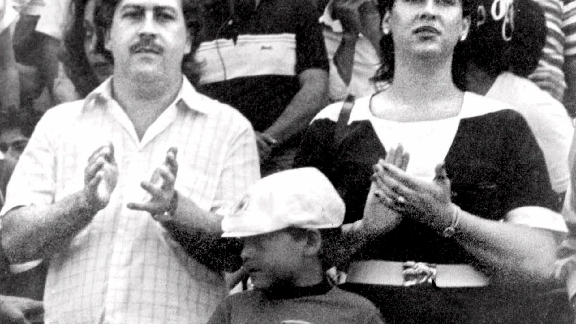 FILE - In this undated file photo, the late Pablo Escobar, former boss of the Medellin drug cartel, his wife Maria Henao and their son Juan Pablo, attend a soccer match in Bogota, Colombia. The widow of Pablo Escobar fell madly in love as a preteen with the man who would rise to be a ruthless drug lord, but says in a new book she felt raped when at age 14 he forced her to have an abortion, and over time came to view him as a cruel psychopath. (El Tiempo Photo via AP File)