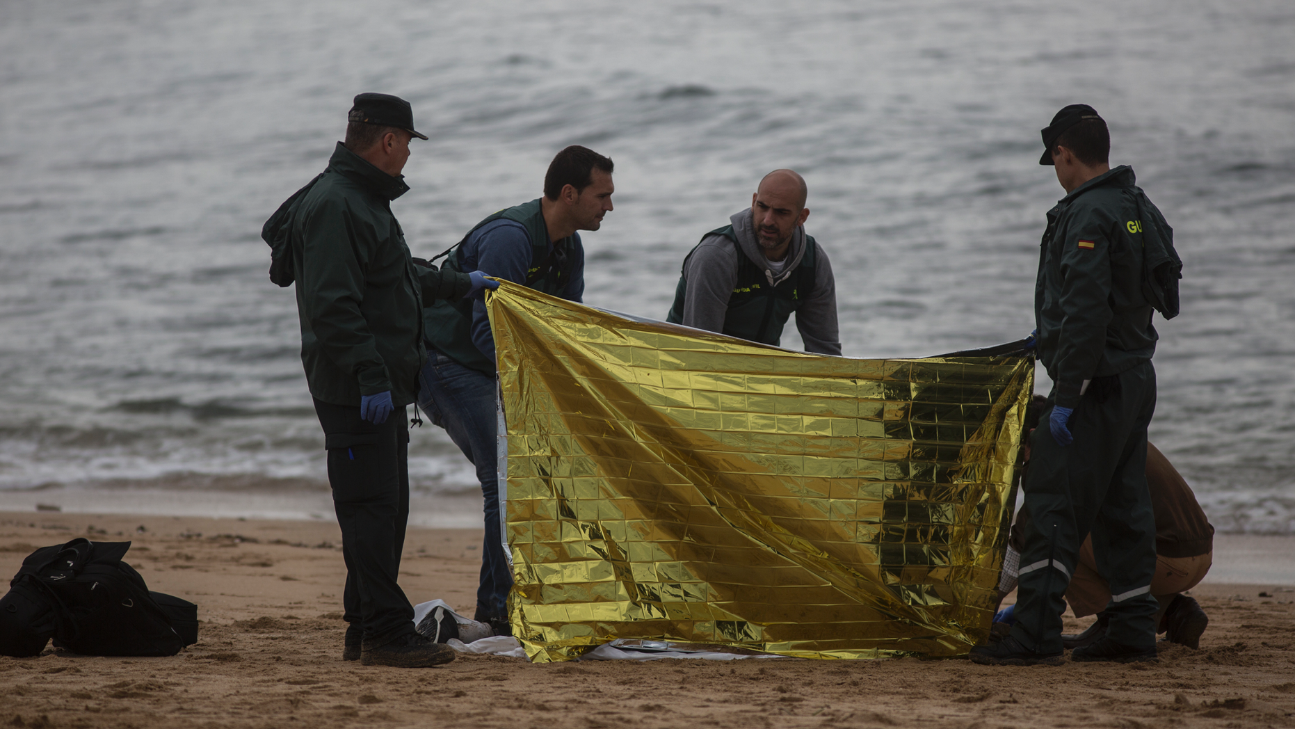 Members of the Spanish Civil Guard inspect the body of a dead migrant found on the beach at the village of Canos de Meca, where seventeen bodies were recovered from the sea after their precarious vessel impacted rocks while trying to reach Spanish coasts in the past week, Barbate, Spain, Monday, Nov. 12, 2018. (AP Photo/Javier Fergo)