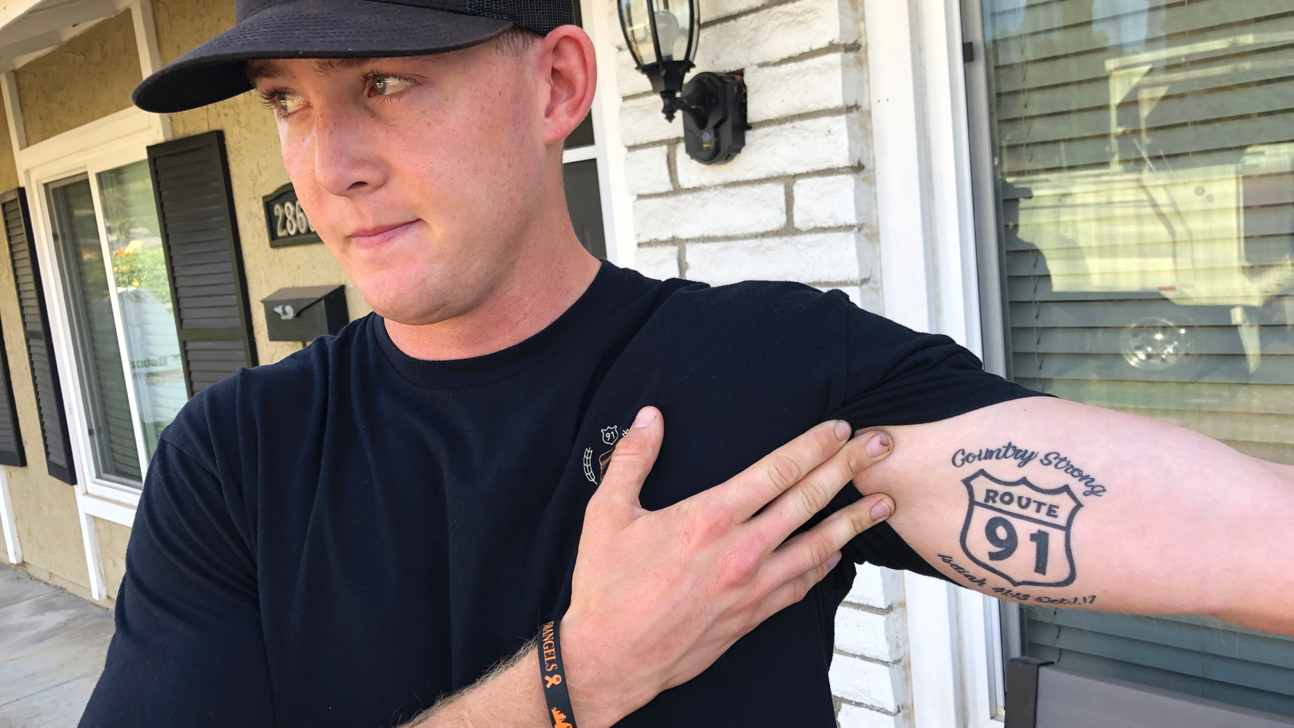 Brendan Kelly speaks with reporters outside his home, as he shows his Route 91 tattoo, Thursday, Nov. 8, 2018, in Thousand Oaks, Calif. Kelly, a Marine who was at Borderline Bar and Grill on Wednesday night, helped people get out after a gunman opened fire at the establishment. Kelly also survived the Las Vegas Route 91 Harvest Festival shooting in 2017. (AP Photo/Ryan Pearson)