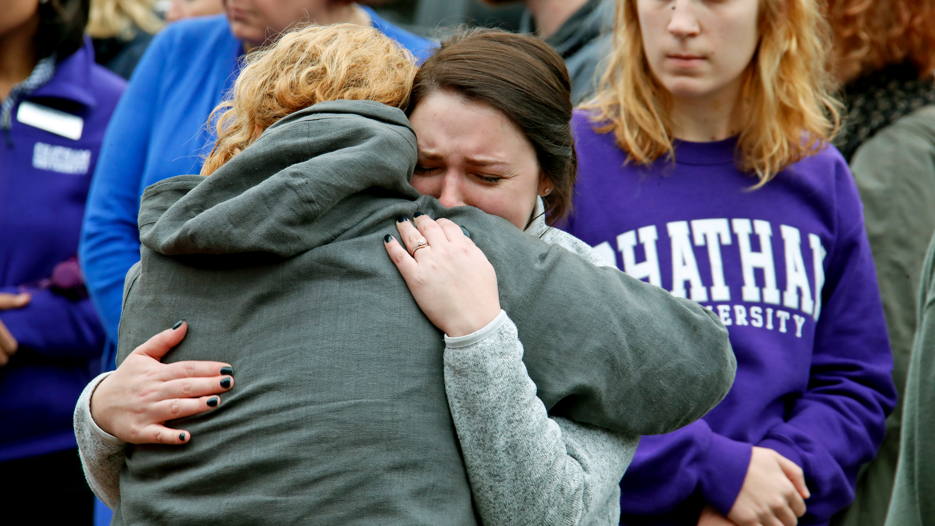 Chatham University students hug during a visit Thursday, Nov. 1, 2018, to a makeshift memorial outside the Tree of Life synagogue dedicated to the 11 people killed Oct. 27 while worshipping, in the Squirrel Hill neighborhood of Pittsburgh. (AP Photo/Gene J. Puskar)