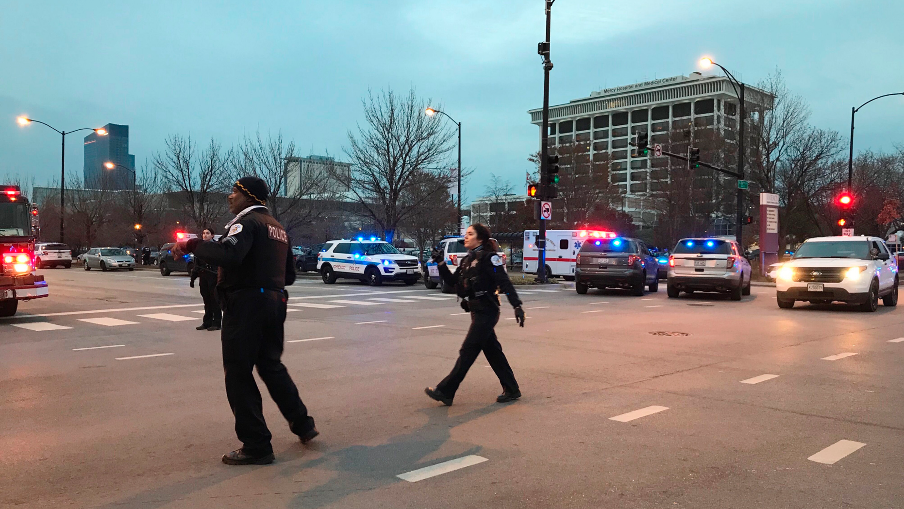 Chicago Police officers walk outside Mercy Hospital on the city's South Side where authorities say a shooting at the hospital has wounded multiple people, including a suspect and a police officer, Monday, Nov. 19, 2018, in Chicago. (AP Photo/Amanda Seitz)