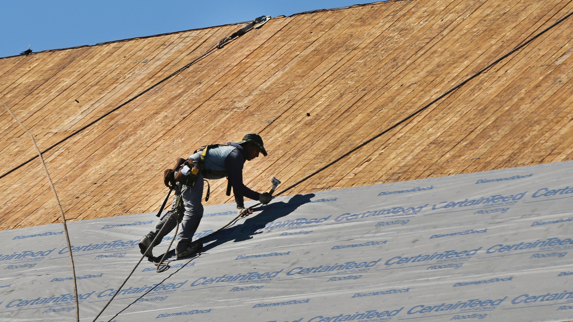 FILE- In this July 19, 2018, file photo a roofer works on top of the church at St. Lucy Parish in Methuen, Mass. On Monday, Nov. 5, the Institute for Supply Management, a trade group of purchasing managers, issues its index of non-manufacturing activity for September. (AP Photo/Elise Amendola, File)