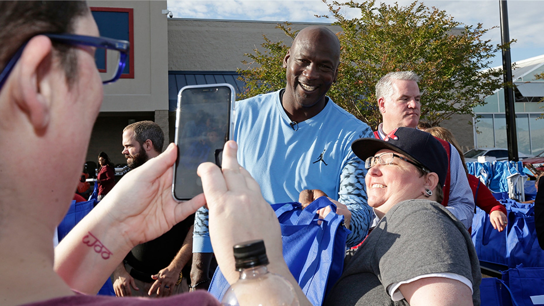 Charlotte Hornets owner Michael Jordan poses for a photo while greeting people and handing out food for Thanksgiving to members of the community in Wilmington, N.C., Tuesday. (AP Photo/Gerry Broome)