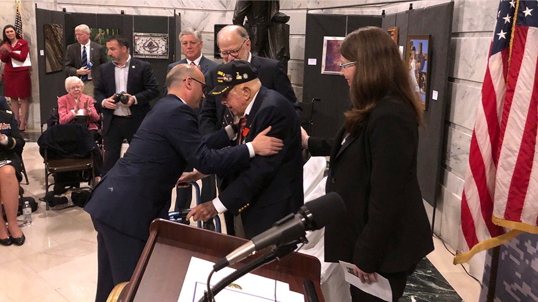 French Consul General Guillaume Lacroix, left, embraces retires Lt. Col. William Pollard after awarding him the French Legion of Honor on Monday, Nov. 19, 2018, in Frankfort, Kentucky. Pollard is a 100-year-old World War II veteran who lives in Kentucky. He was part of the Allied invasion of France in 1944. (AP Photo/Adam Beam)