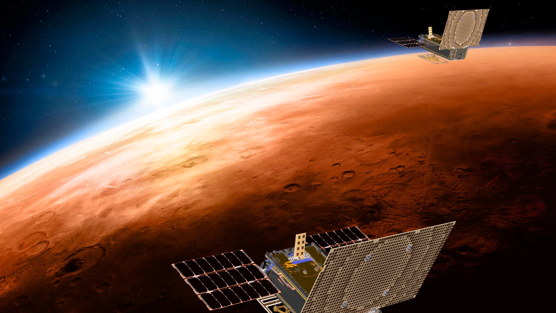 FILE - This illustration made available by NASA in March 2018 shows the twin Mars Cube One project (MarCO) spacecrafts flying over Mars with Earth and the sun in the distance. (NASA/JPL-Caltech via AP)