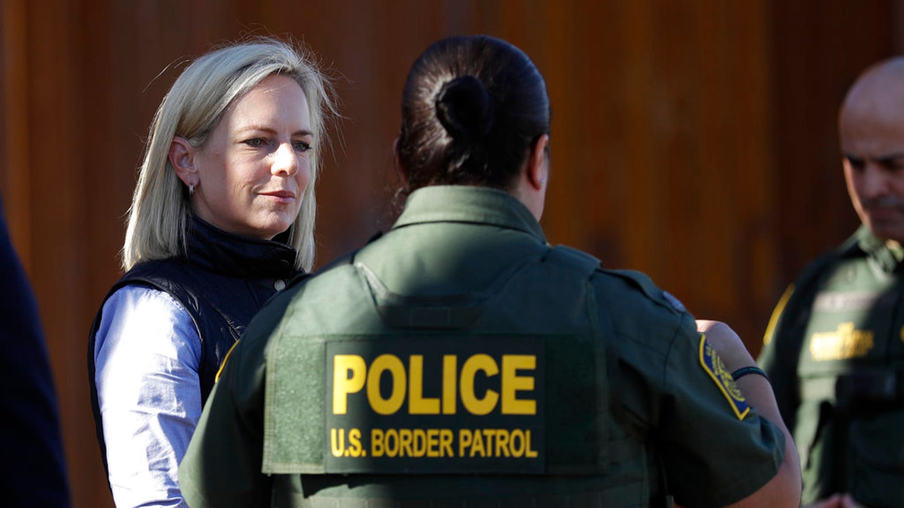 U.S. Department of Homeland Security Secretary Kirstjen Nielsen, left, speaks with Border Patrol agents near a newly fortified border wall structure in Calexico, Calif. (AP Photo/Gregory Bull)
