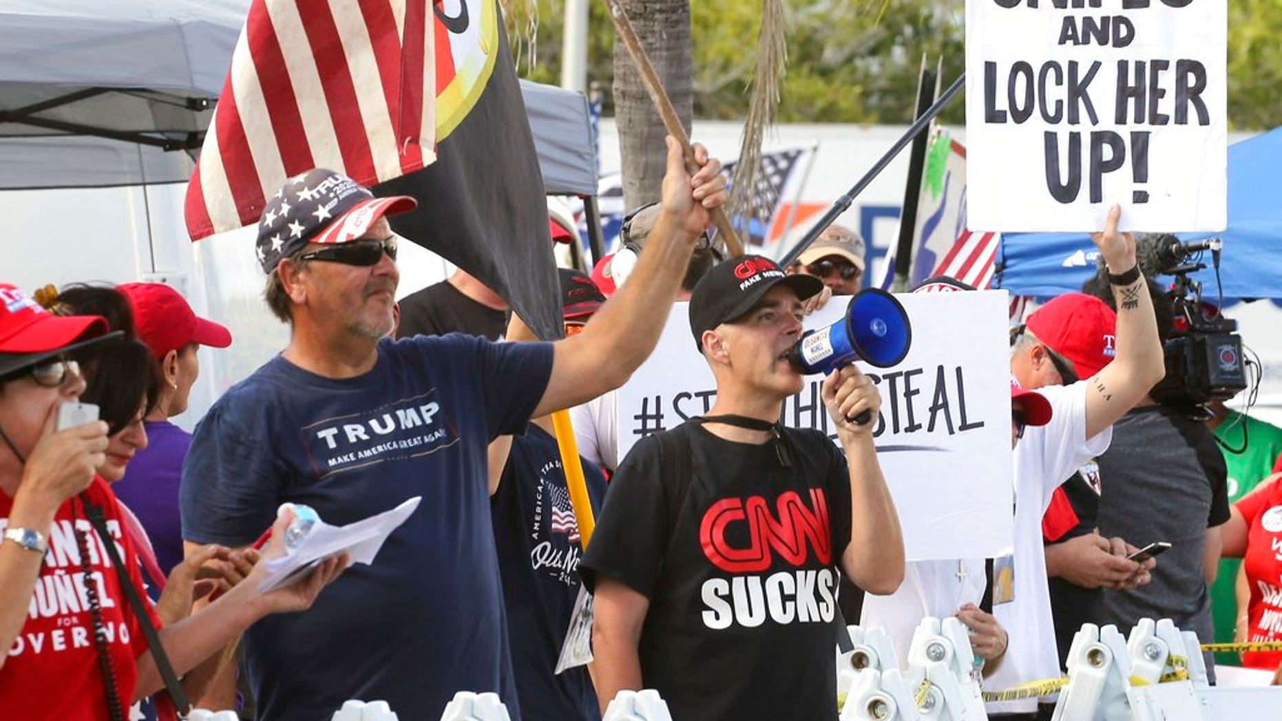 A crowd of protestors gather outside the Broward County of Supervisor of Elections Office as the statewide election recount is underway while ballots for governor, Senate, Agricultural Commission were run through scanning machines in Broward for a second time under the watchful eye of representatives of both parties and the campaigns. (Carl Juste/Miami Herald via AP)
