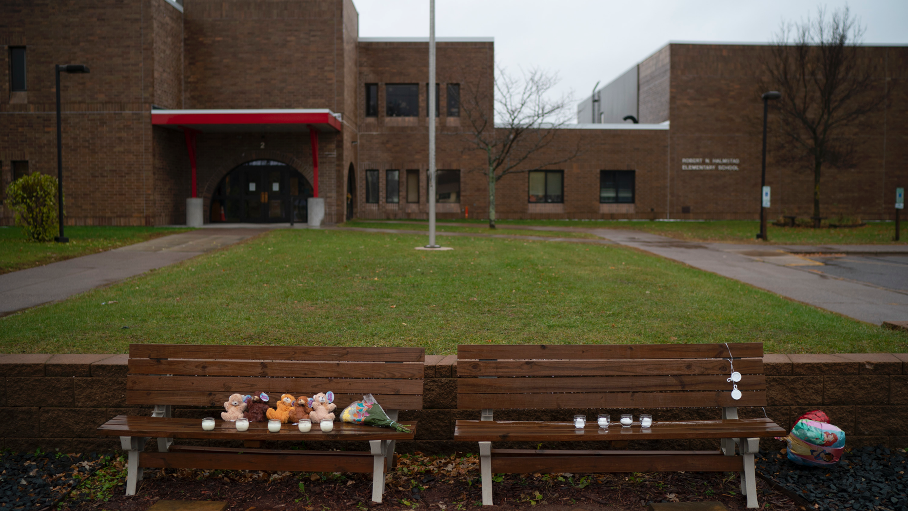 Teddy bears, flowers, and candles were placed on benches outside Halmstad Elementary School in Chippewa Falls, Wis. as a memorial to the three Girl Scouts who were struck and killed by a driver who fled the scene, Sunday, Nov. 4, 2018. The western Wisconsin community is grieving the deaths of three girls and an adult who were collecting trash along a rural highway when police say a pickup truck veered off the road and hit them before speeding away. (Jeff Wheeler/Star Tribune via AP)