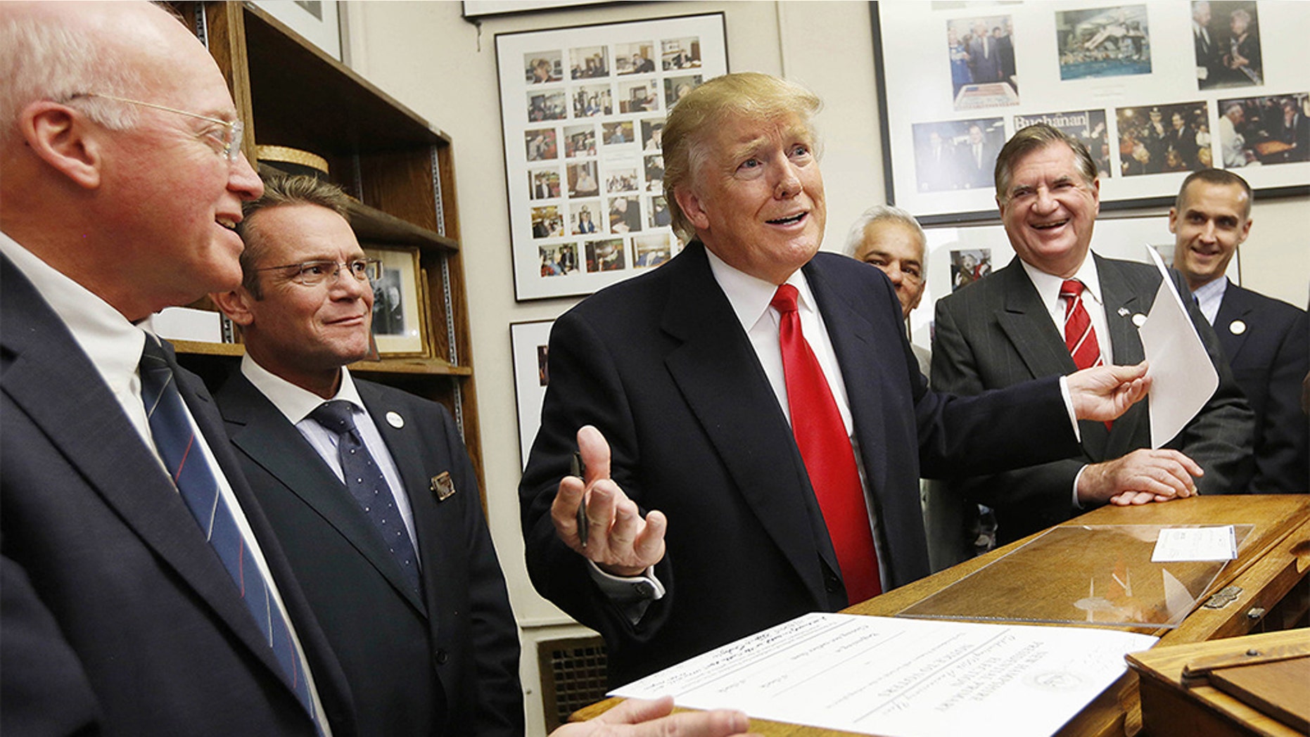 In this Nov. 4, 2015, file photo, New Hampshire Secretary of State Bill Gardner, left, watches as then-Republican presidential candidate Donald Trump fills out his filing papers to be on the primary ballot at the Secretary of State's office in Concord, N.H. (AP Photo/Jim Cole, File)
