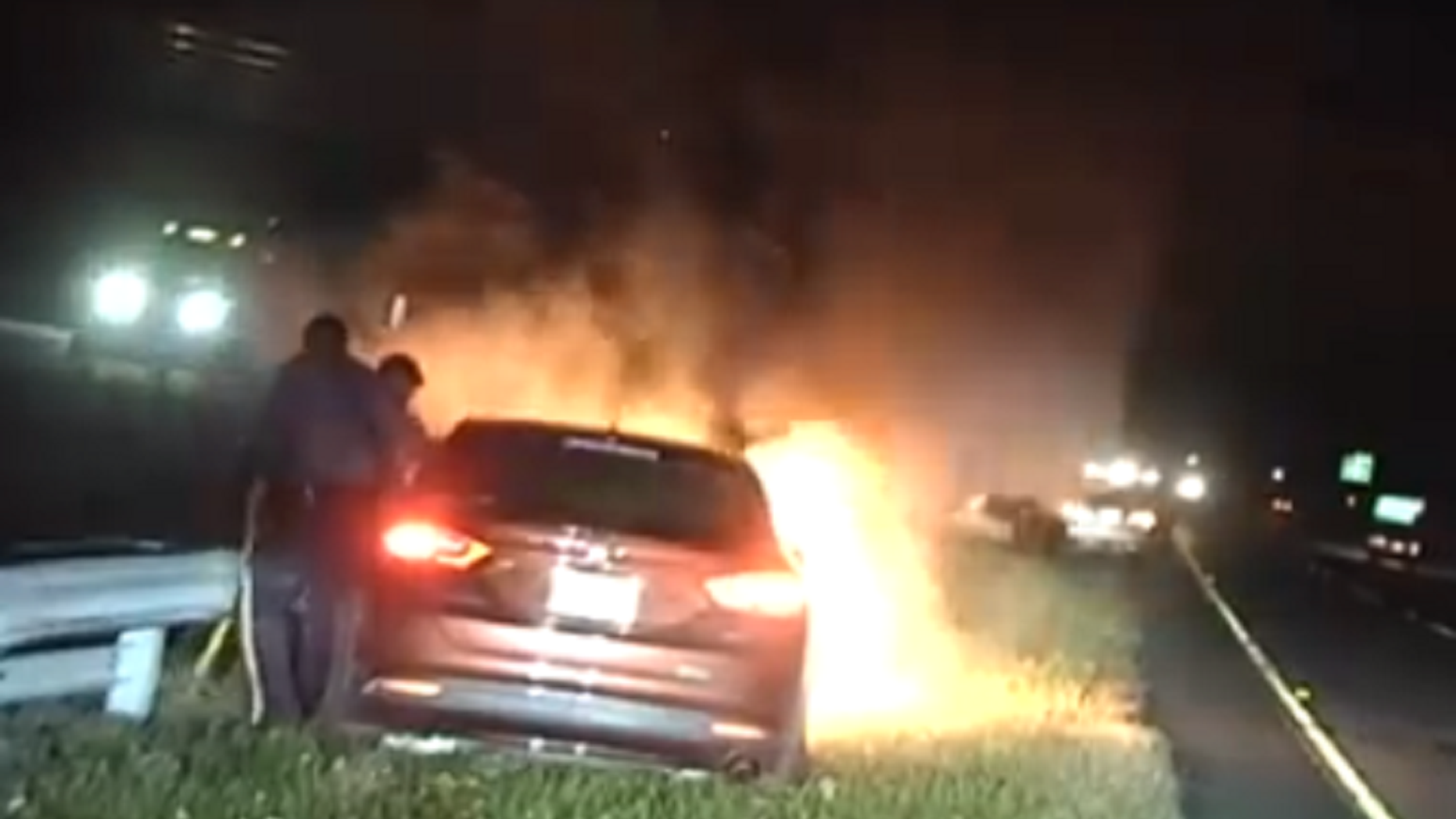 Two New Jersey State Police troopers rescue an unconscious motorist from a burning car.