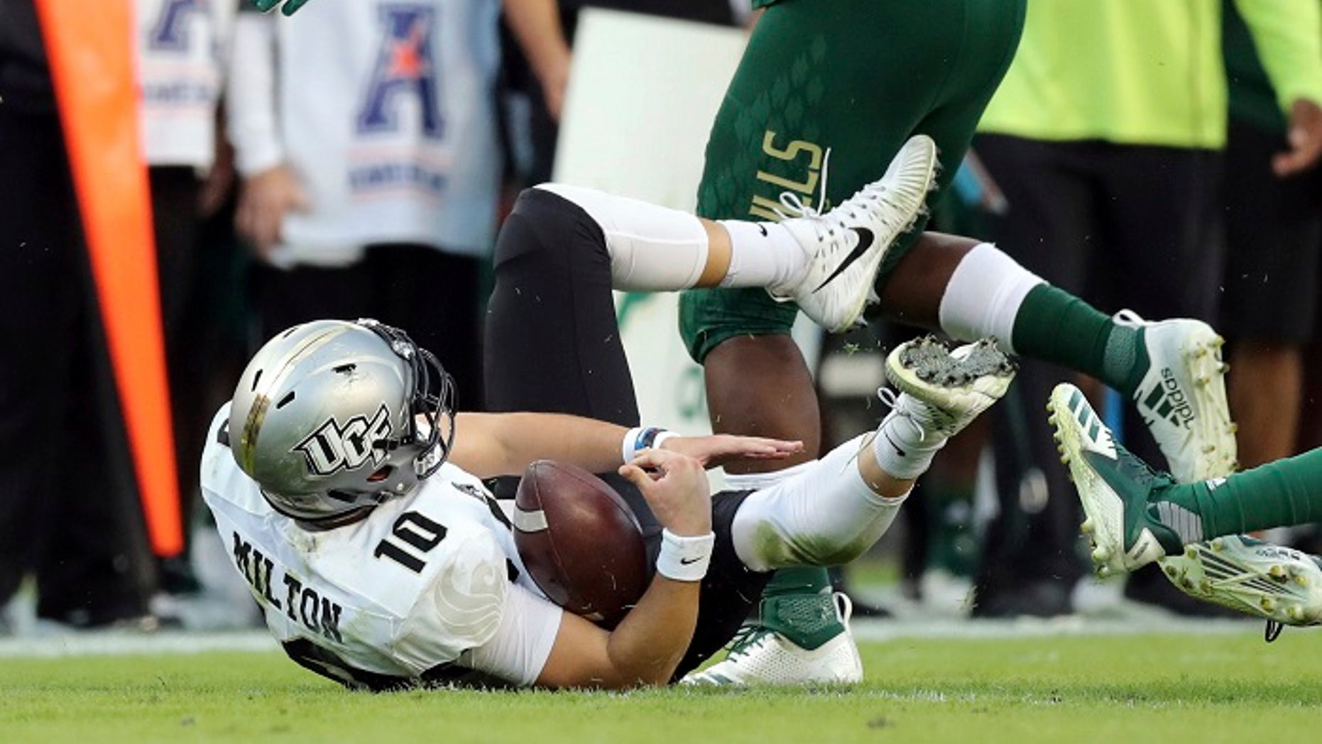 UCF quarterback McKenzie Milton goes down with an apparent knee injury after being tackled in a game against South Florida on Friday, Nov. 23, 2018.