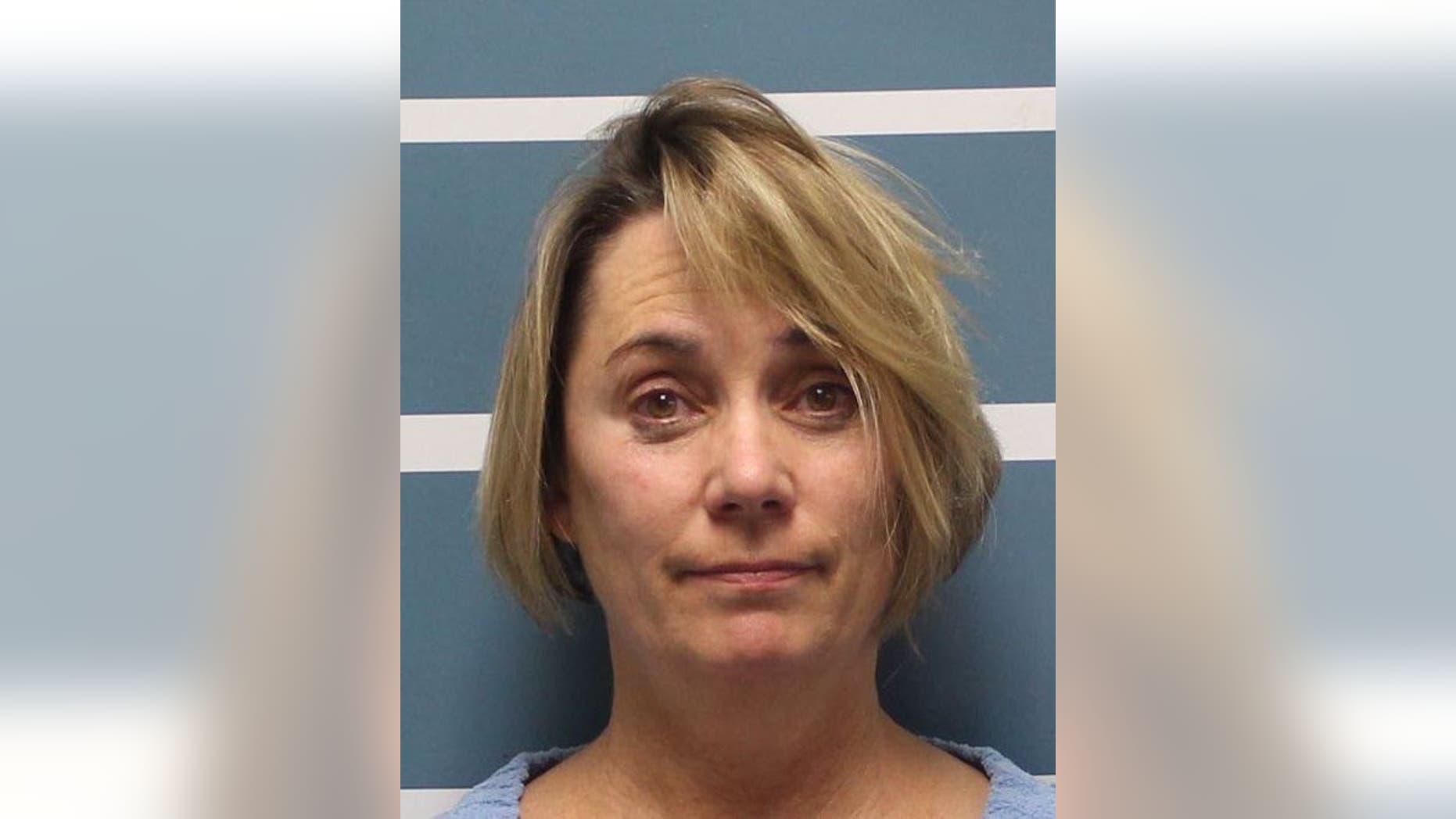 Margaret Gieszinger, 52, was arrested after she was seemingly caught in a video cutting hair off a student's head while incorrectly singing "The Star-Spangled Banner."