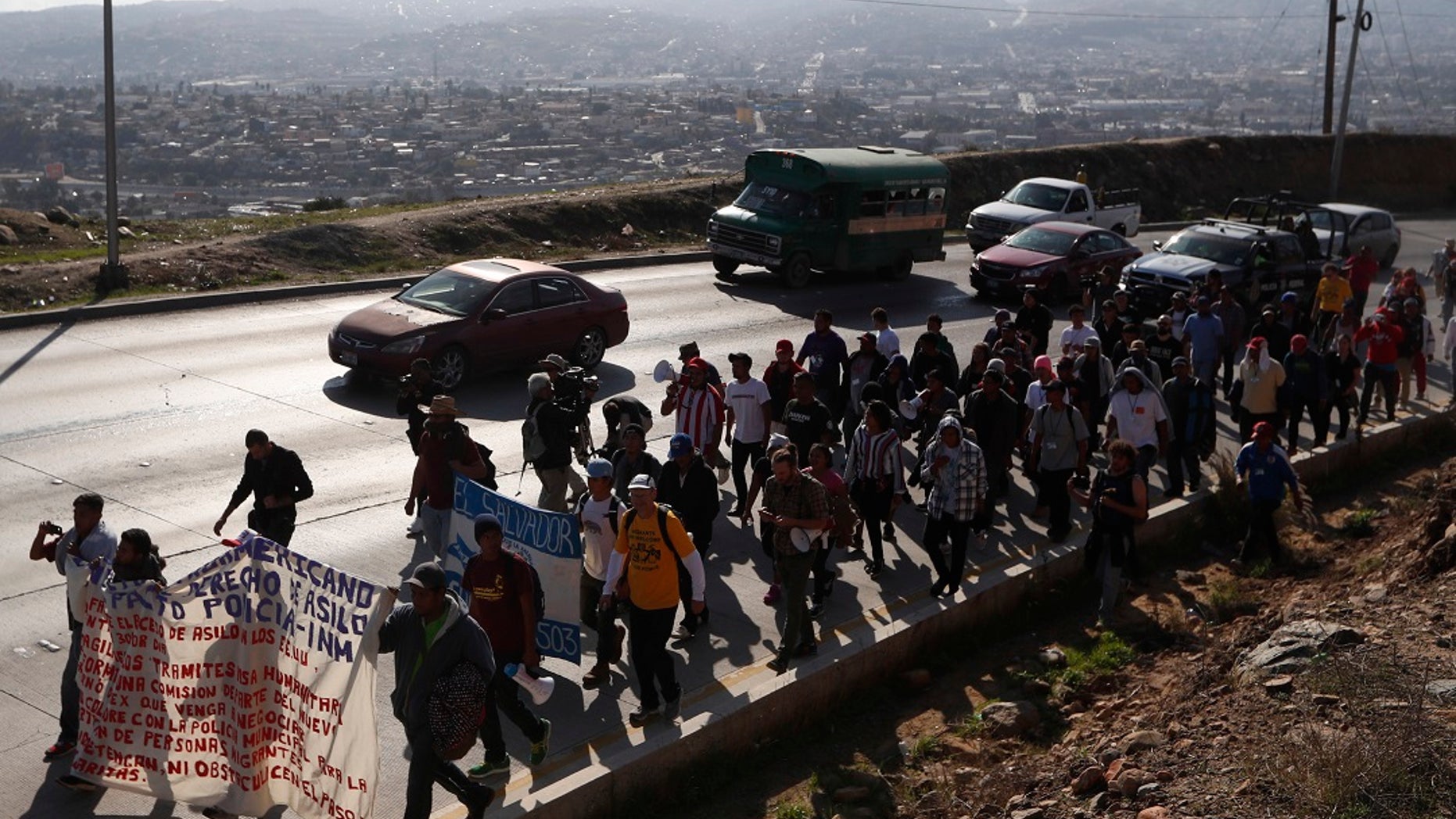 Central American migrants march to the U.S. consulate in Tijuana, Mexico, Tuesday, Dec. 11, 2018. [AP Photo/Moises Castillo)