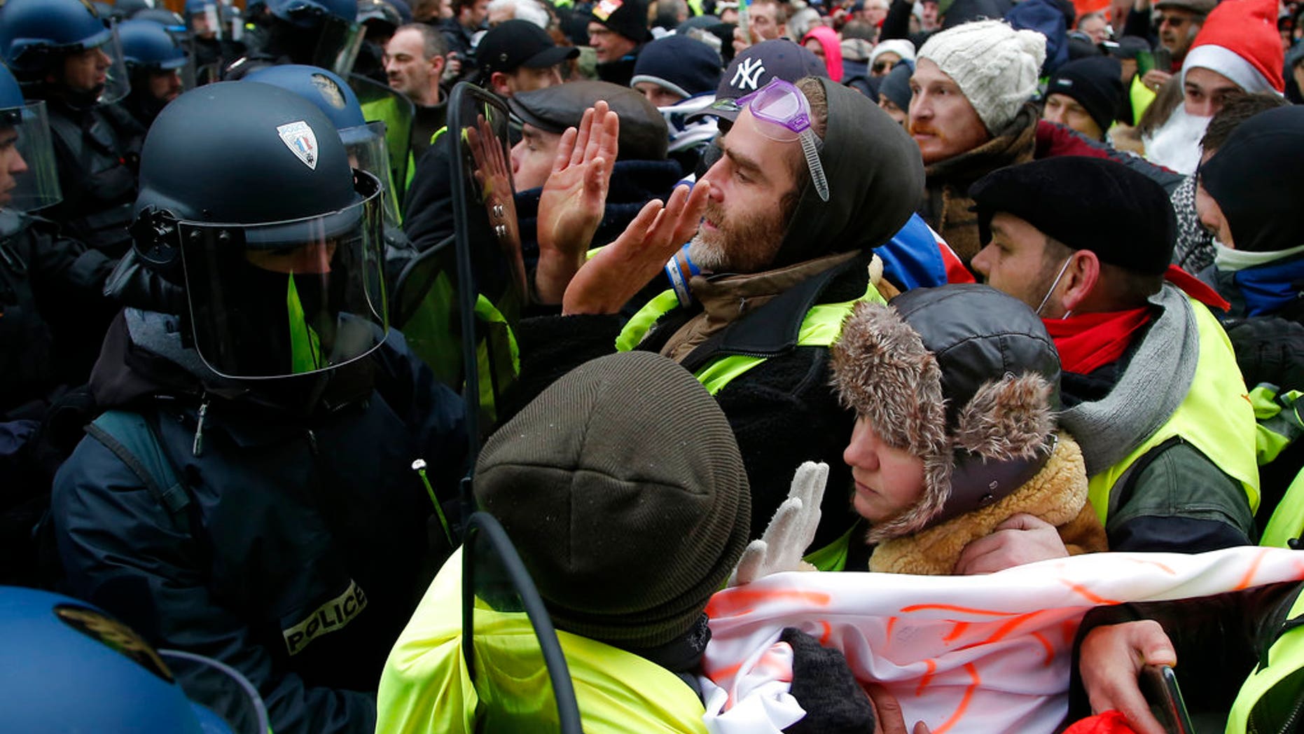 Demonstrators face riot police officers during a protest Saturday, Dec. 15, 2018 in Paris. (AP Photo/Michel Euler)
