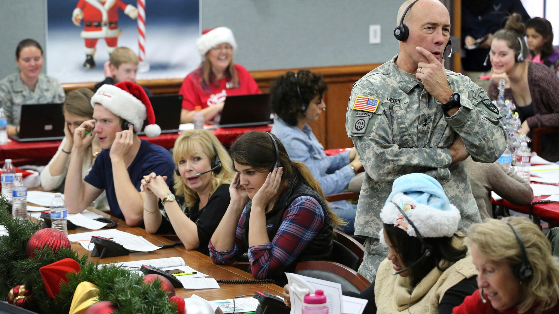 In this Dec. 24, 2014, file photo, NORAD Chief of Staff Maj. Gen. Charles D. Luckey takes a call while volunteering at the NORAD Tracks Santa center at Peterson Air Force Base in Colorado Springs, Colo. Hundreds of volunteers will help answer the phones from children around the world calling for Santa when the program resumes on Monday, Dec. 24, 2018, for the 63rd year. (AP Photo/Brennan Linsley, File)