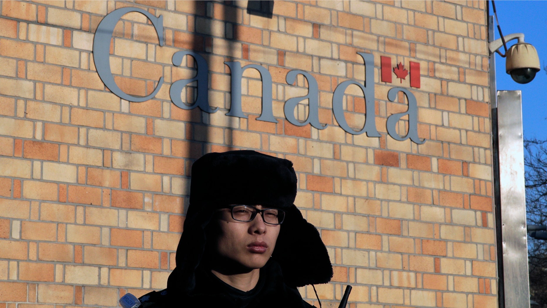 A policeman stands watch outside the Canadian Embassy in Beijing, Wednesday, Dec. 12, 2018. A Canadian court granted bail on Tuesday to a top Chinese executive arrested at the United States' request in a case that has set off a diplomatic furor among the three countries and complicated high-stakes U.S.-China trade talks. (AP Photo/Andy Wong)