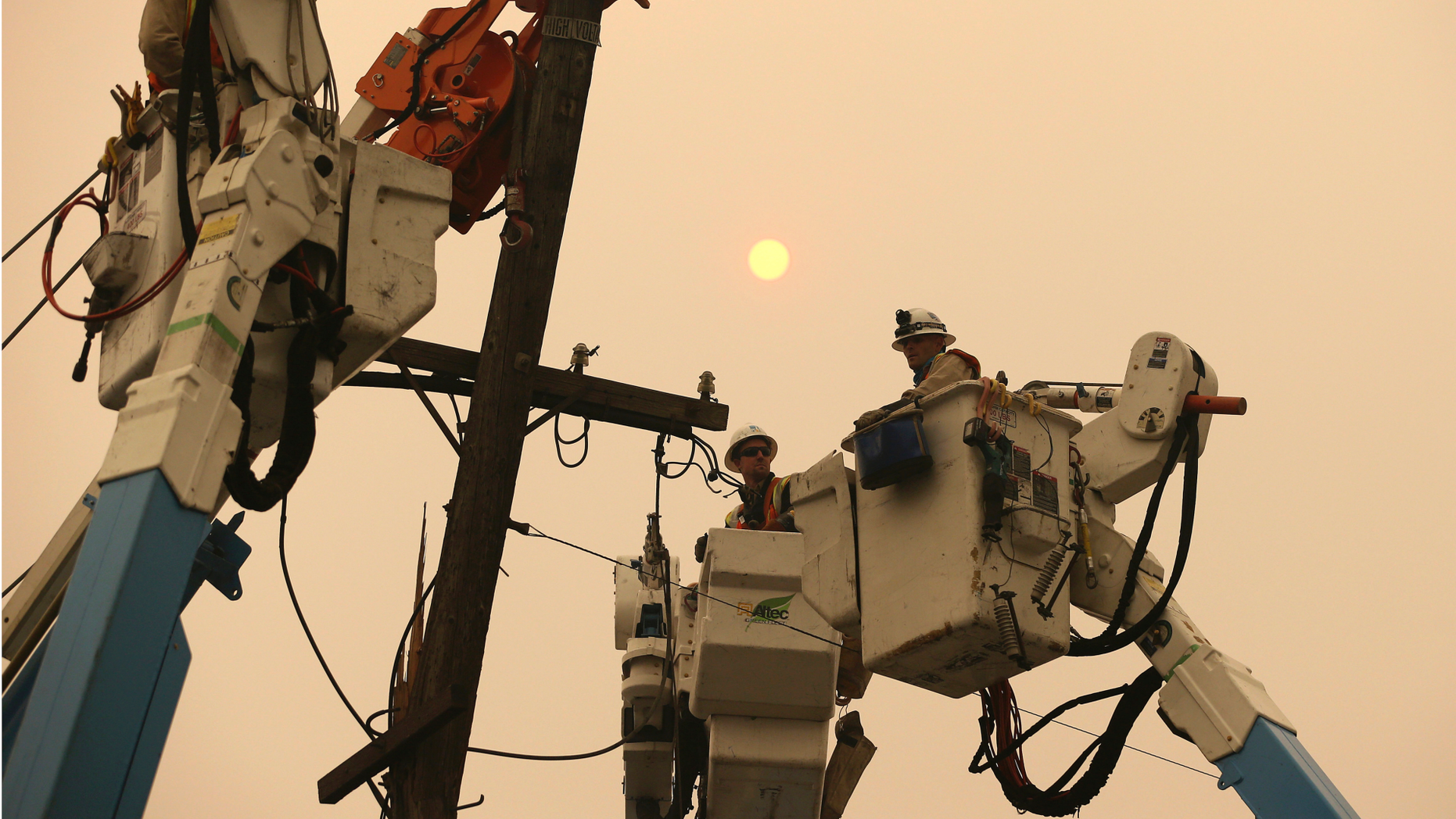 FILE - In this Nov. 9, 2018 file photo, Pacific Gas & Electric crews work to restore power lines in Paradise, Calif. The Northern California utility on Monday, Dec. 17, said it terminated one of its contractors helping with wildfire recovery after three workers posted on social media insensitive photos and comments poking fun at victims and the region. (AP Photo/Rich Pedroncelli, File)