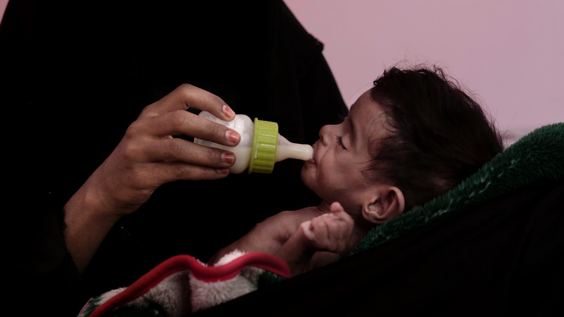 FILE - In this Feb. 13, 2018 file photo, Ahmed Rashid Mokbel, a severely malnourished 7-month-old Yemeni boy, is given formula by his mother at the Al-Sadaqa Hospital in Aden, Yemen. Oxfam, an international aid group, said Wednesday, Dec. 19, 2018, that more than half a million displaced people in war-torn Yemen face the "double threat" of famine and freezing temperatures as winter sets in. Oxfam said that some 530,000 displaced people are in mountainous areas, many living in makeshift shelters with no insulation or weatherproofing. (AP Photo/Nariman El-Mofty, File)
