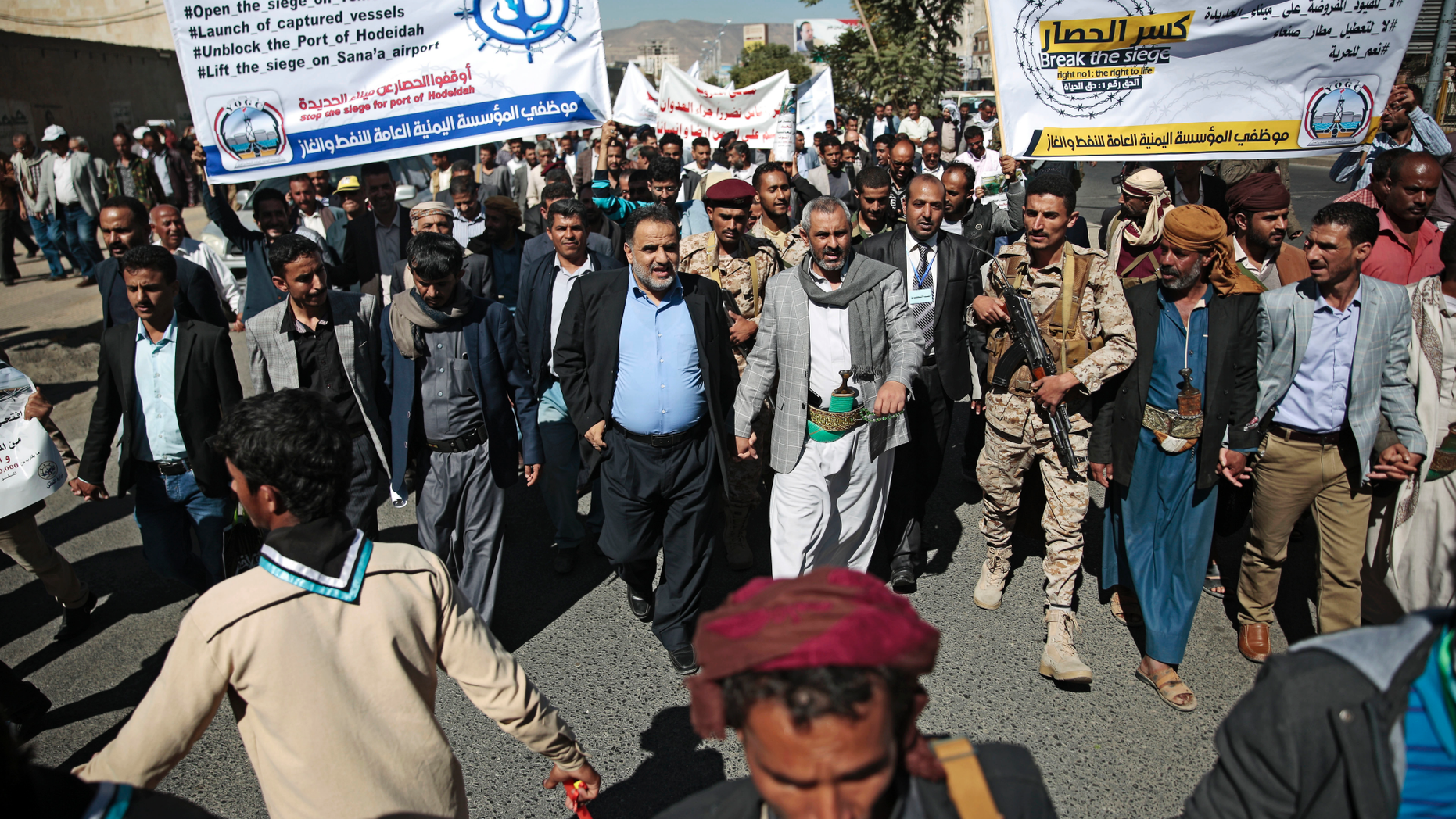 Yemenis hold banners as they take part in a protest calling for the reopening of Sanaa airport to receive medical aid, in front of the U.N. offices in Sanaa, Yemen, Monday, Dec. 10, 2018. (AP Photo/Hani Mohammed)