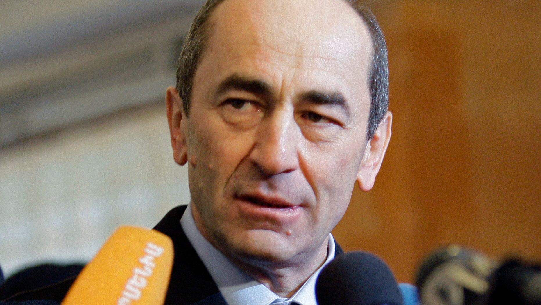 FILE- In this file photo dated Tuesday, Feb. 19, 2008, Armenian President Robert Kocharian talks to the media at a polling station in Yerevan, Armenia. An Armenian court has ruled that the nation's former president should be put in custody on charges linked to the dispersal of a 2008 protest. (AP Photo/Misha Japaridze, File)