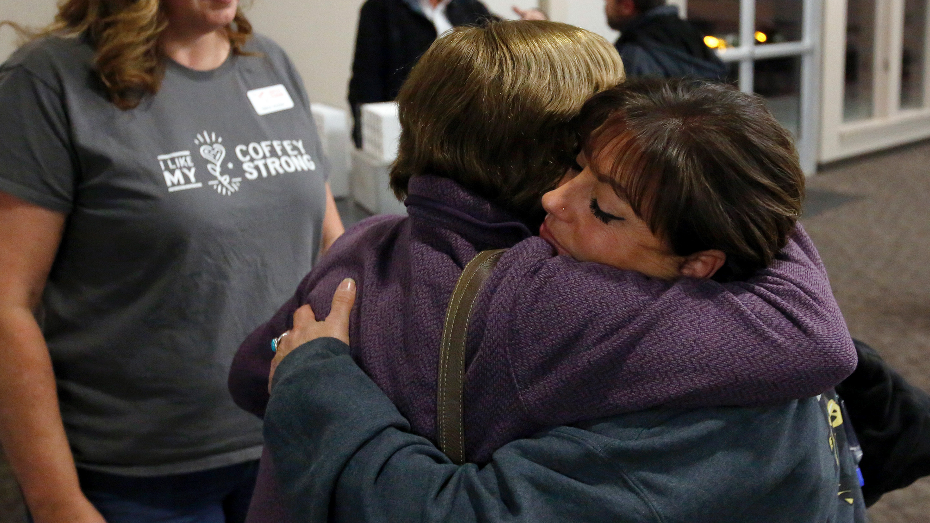 In this photo taken Tuesday, Dec. 11, 2018, Camp Fire survivor Terese Mangino, right, embraces Tubbs Fire survivor Anne Barbour as fellow survivor Tricia Woods, left, looks on, after a meeting with Camp Fire survivors in Chico, Calif. Survivors of a deadly wildfire that last year tore through California's wine country are sharing lessons of loss and pain but also of resilience with those who last month escaped the deadliest U.S. wildfire in at least a century. The Press Democrat reports a group of Sonoma County residents spent Tuesday in a packed meeting with residents of Paradise and several nearby communities who grilled them with questions. (Alvin Jornada/The Press Democrat via AP)