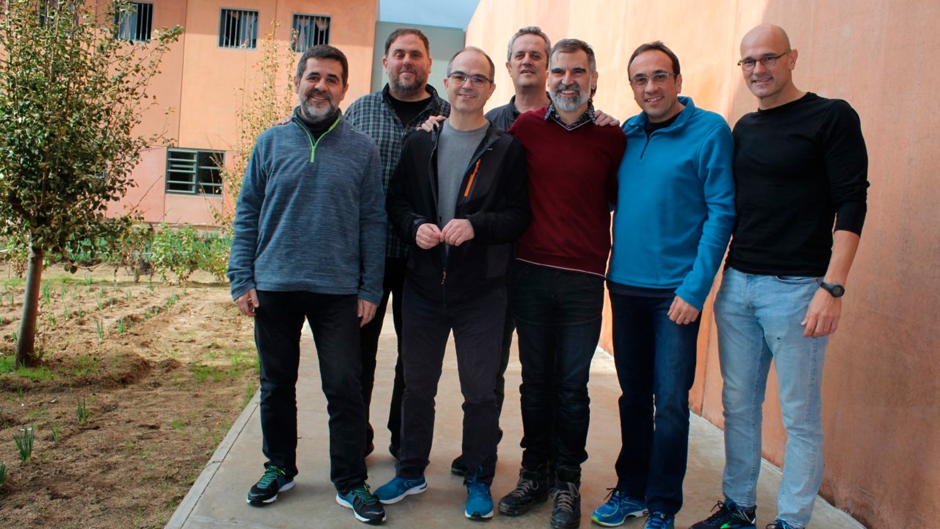 In this undated photo provided by Catalan language association Omnium Cultural, showing jailed Catalan separatist leaders posing for a photo inside Lledoners jail in Sant Joan de Vilatorrada, 50 kms from Barcelona, Spain, with left to right; Jordi Sanchez, Oriol Junqueras, Jordi Turull, Joaquim Forn, Jordi Cuixart, Josep Rull and Raul Romeva. Jordi Sanchez and Jordi Turull, have been in a medical ward since Friday Dec. 14, 2018, as the hunger strike by the group of Catalan politicians enters its third week and begins to take a toll on their health, but they say their upcoming treason trial will allow them to peacefully promote their cause for independence from Spain. (Maria Vernet/Omnium Cultural via AP)