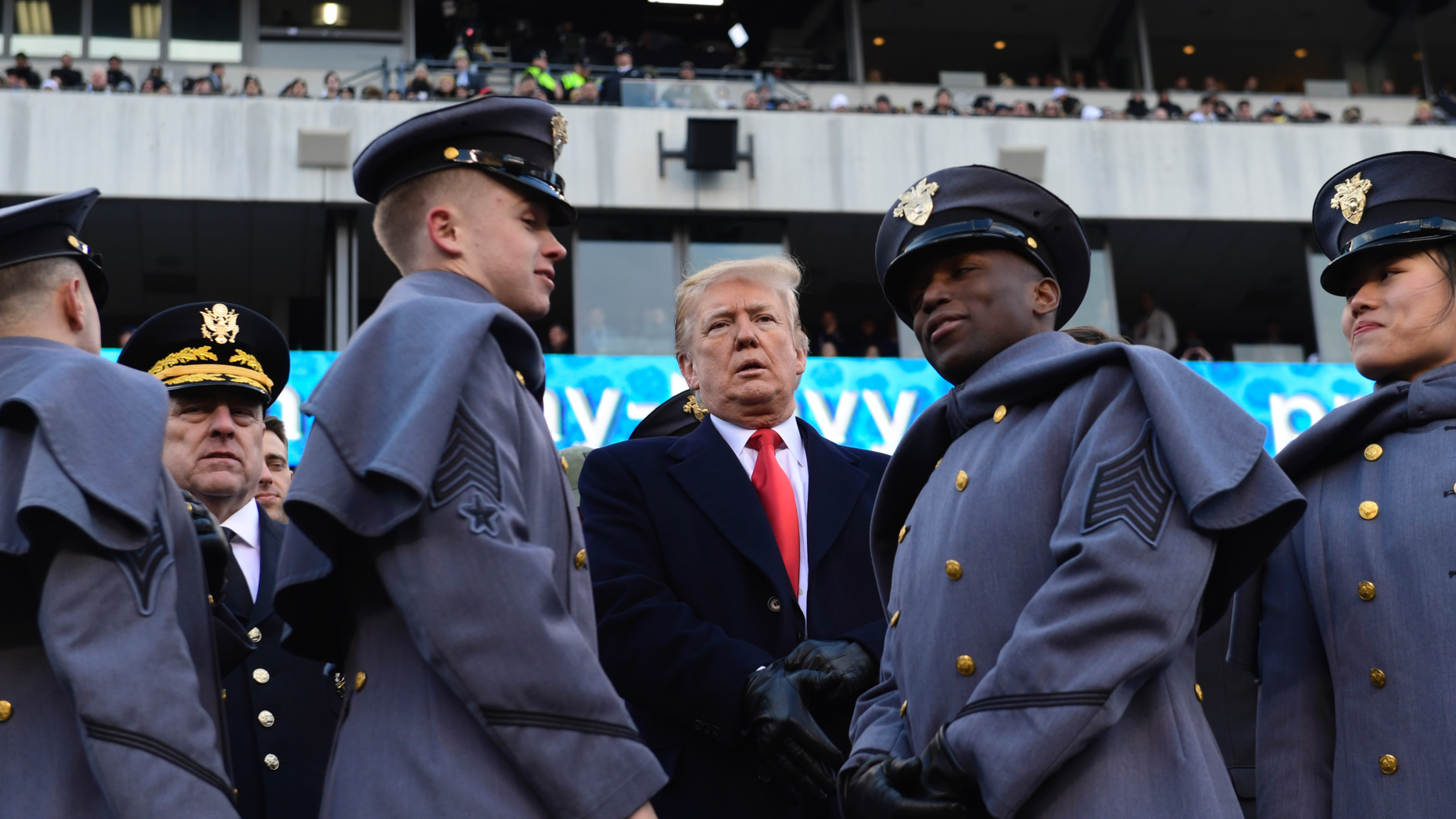 President Donald Trump, center, talks with Army Chief of Staff Gen. Mark Milley, left, watch from the stands before the Army-Navy NCAA college football game in Philadelphia, Saturday, Dec. 8, 2018. (AP Photo/Susan Walsh)