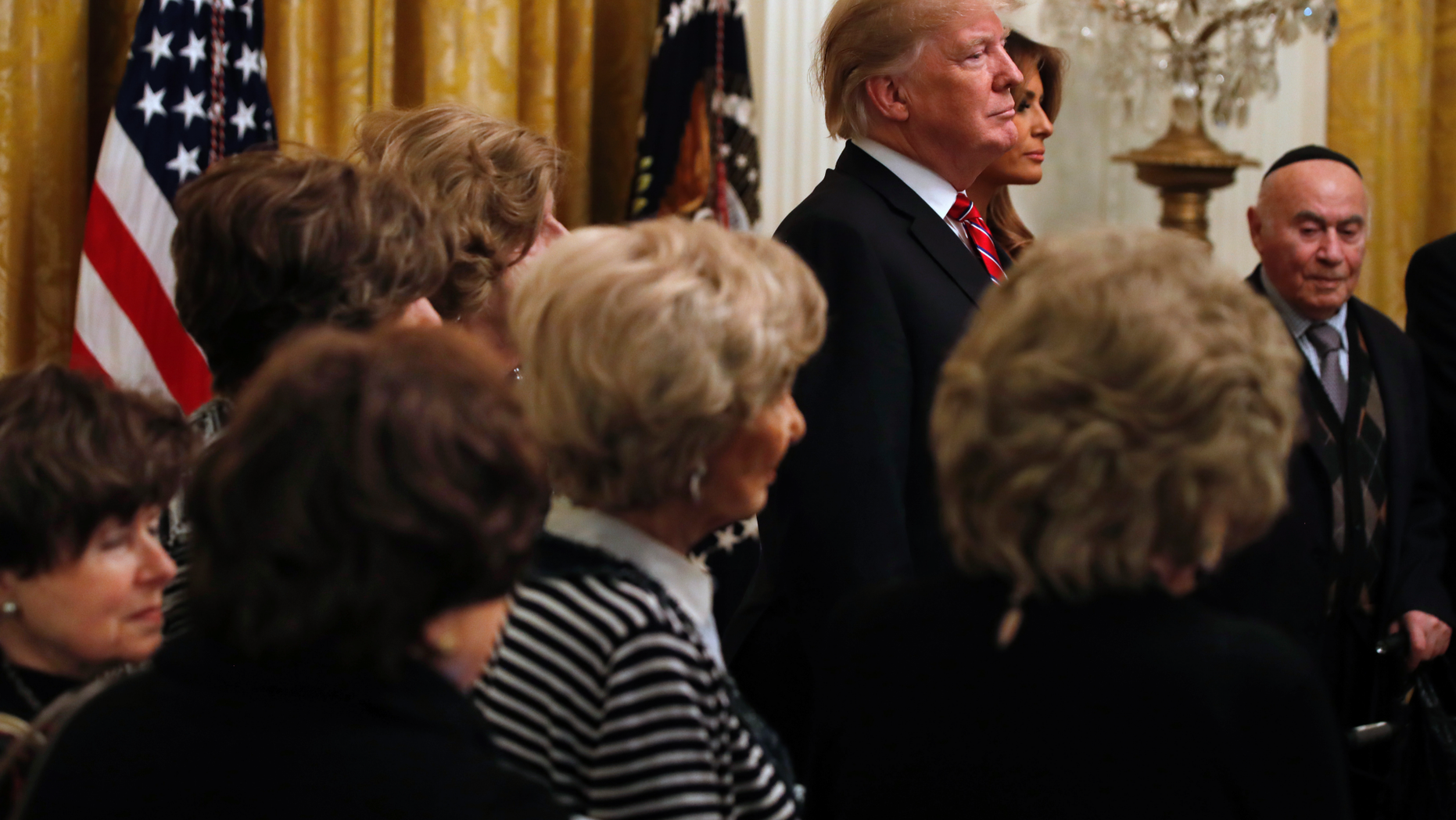 President Donald Trump and first lady Melania Trump are joined by Holocaust survivors, as they attend a Hanukkah reception, Thursday, Dec. 6, 2018, in the East Room of the White House in Washington. The president introduced the attending survivors of the Holocaust, the Nazi genocide of 6 million Jews during WWII, and invited the survivors to join him on stage to see the lighting of the Hanukkah candles. (AP Photo/Jacquelyn Martin)