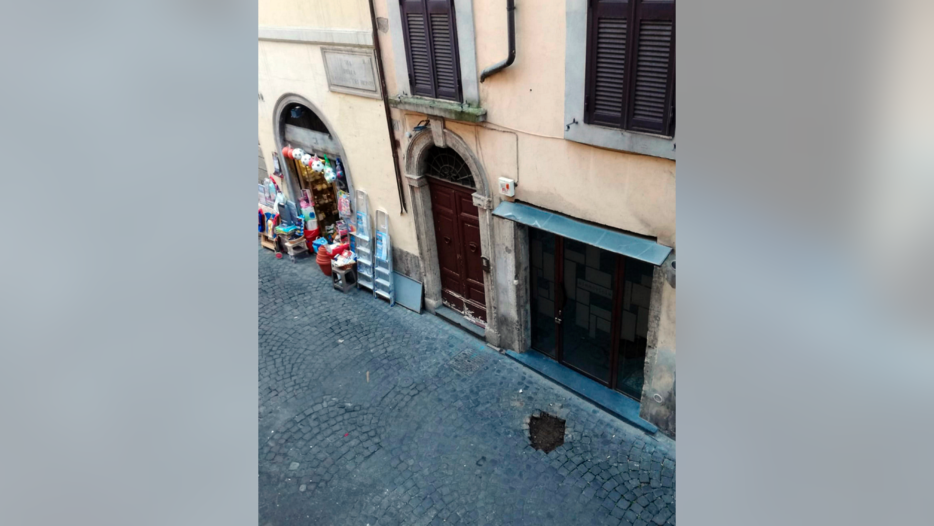 A hole in the cobblestone pavement is seen where 20 small bronze plaques honoring the members of a Jewish family deported during the Holocaust should have been, in Rome's Monti neighborhood, Monday, Dec. 10, 2018.. The plaques, affixed to the cobblestones in front of the Di Consiglio family home, were apparently taken overnight. Rome's historic center houses the Jewish ghetto, near Monti, and its cobblestoned streets are dotted with the plaques in front of homes of Jews who were killed or deported. (Silvia Lambertucci/ANSA via AP)