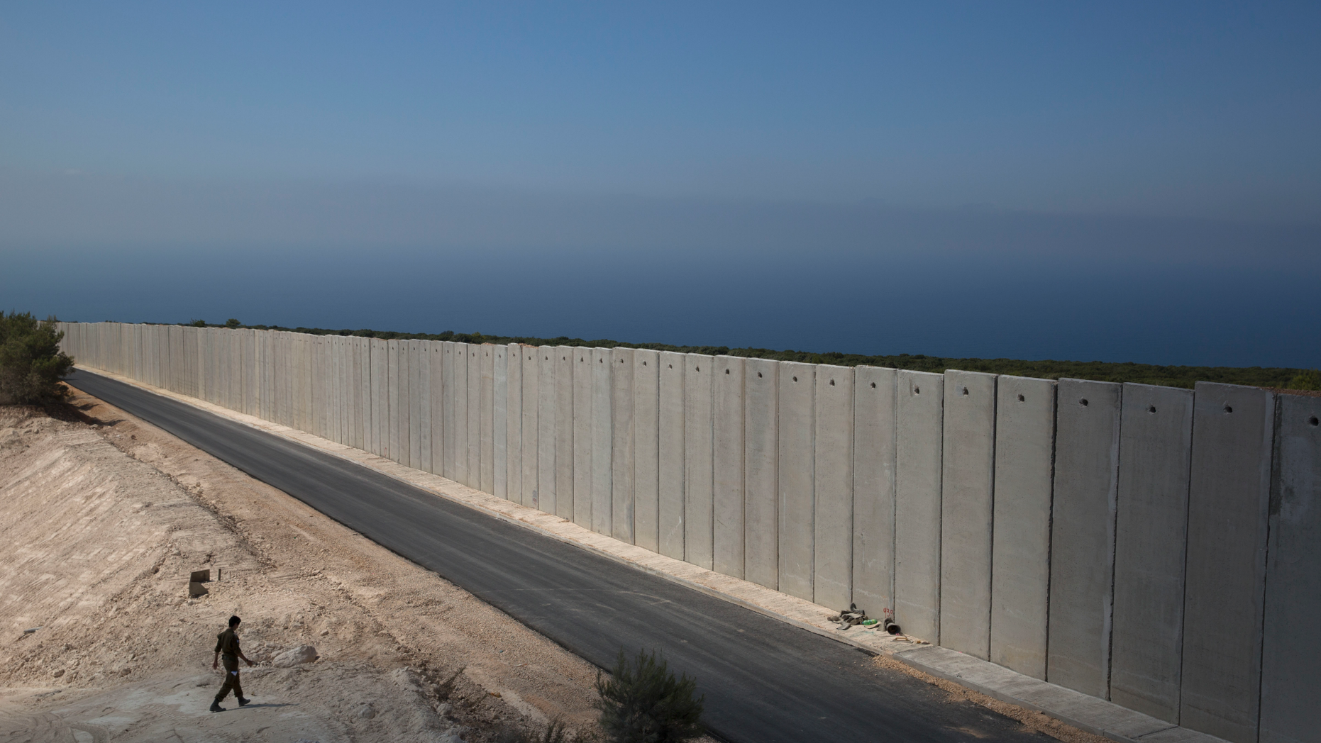 FILE - In this Sept. 5, 2018 file photo, an Israeli soldier stands near a wall at the Israel Lebanon border near Rosh Haniqra, northern Israel. The Israeli military says it has launched an operation meant to "expose and thwart" tunnels built by the Hezbollah militant group and stretching from Lebanon into northern Israel. (AP Photo/Sebastian Scheiner, File)