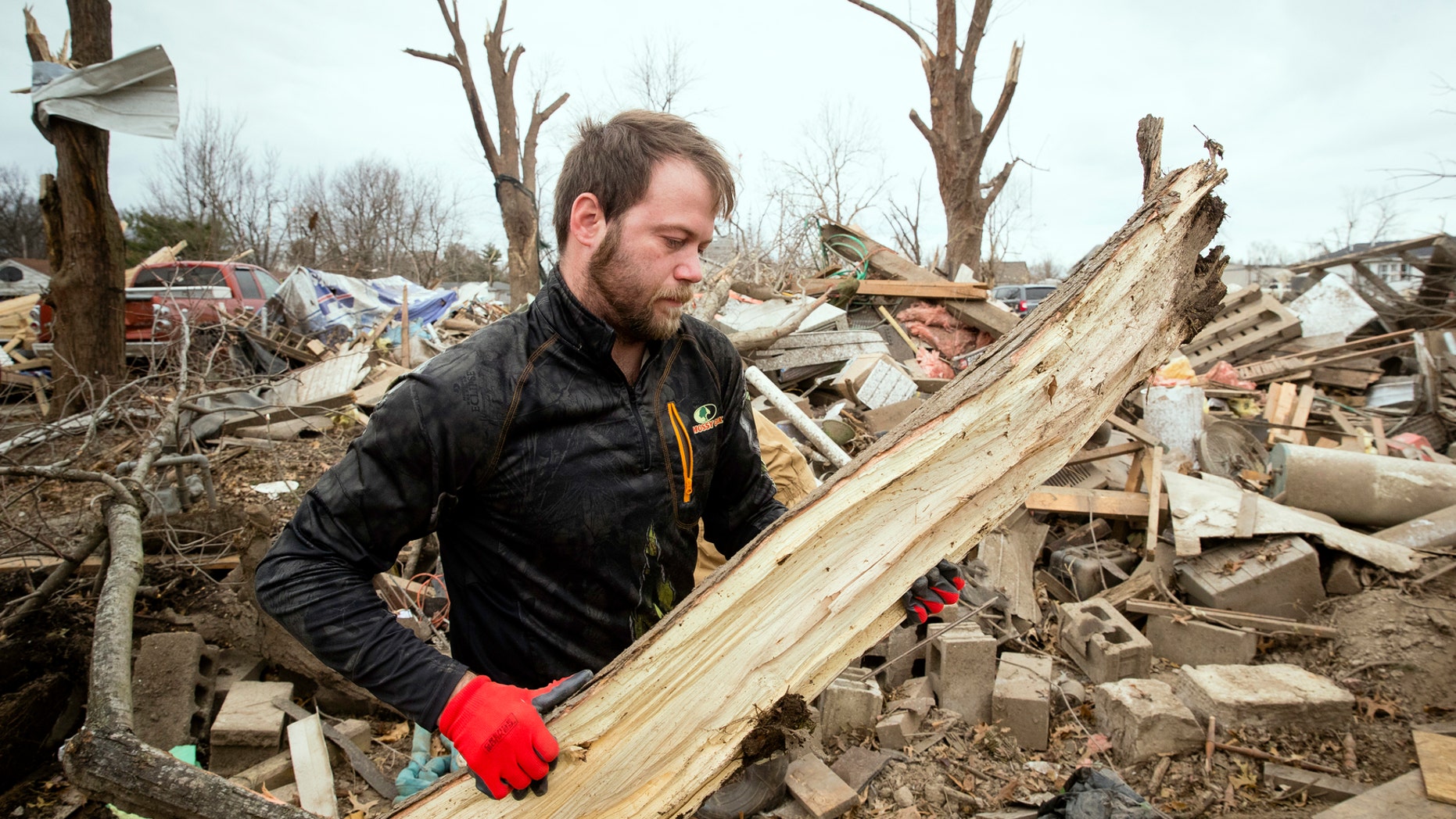 Steven Tirpak cleans debris from the remains of his two-story home in Taylorville, Ill., Sunday, Dec. 2, 2018. Tirpak and his infant were not home when the storm struck. The National Weather Service says multiple tornadoes touched down in central Illinois, damaging dozens of structures and injuring multiple people. (Ted Schurter/The State Journal-Register via AP)