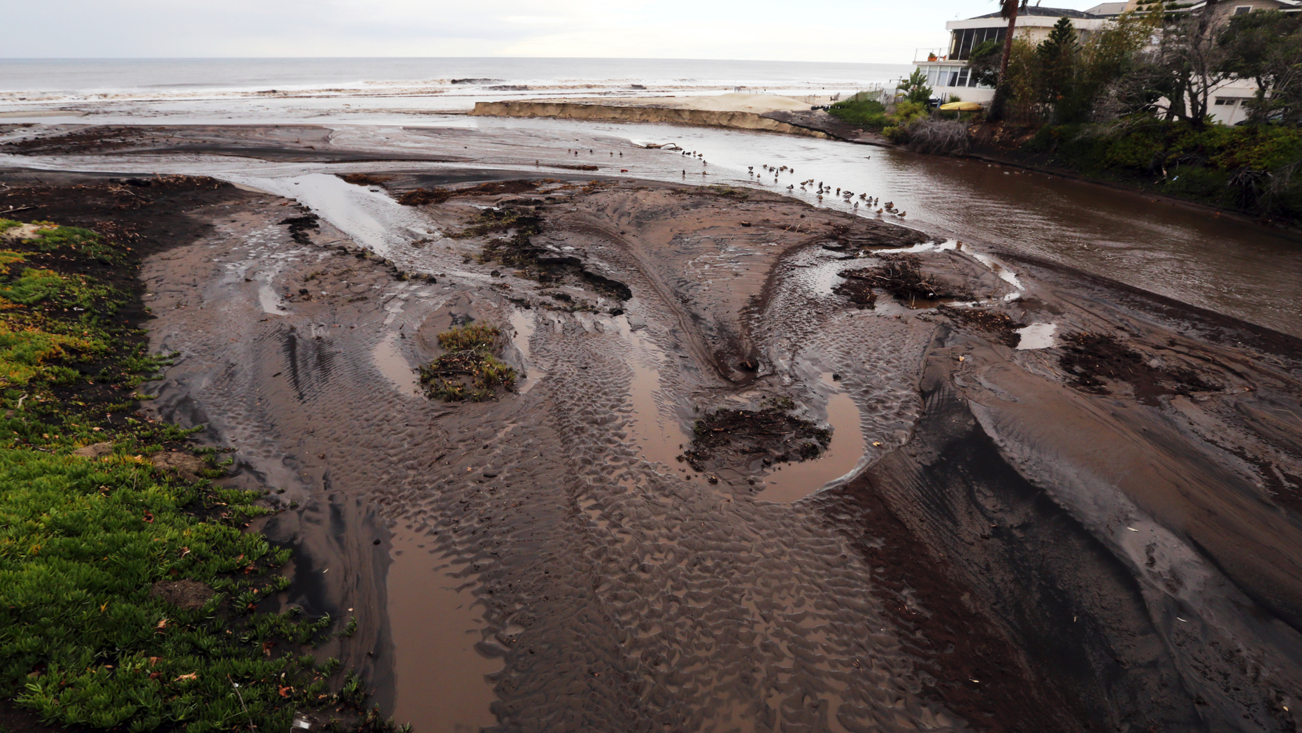 Mud and debris fill the outfall where Trancas Creek flows into the Pacific Ocean in an area burned by the Woolsey fire in Malibu, Calif. Thursday, Dec. 6, 2018. The second round of a fall storm is causing flooding on Los Angeles-area roads. Snow has forced the closure of Interstate 5 in the Grapevine area between Los Angeles and the San Joaquin Valley. Closer to sea level, the system dumped rain that flooded highways and caused nightmare traffic conditions for commuters. (AP Photo/Reed Saxon)